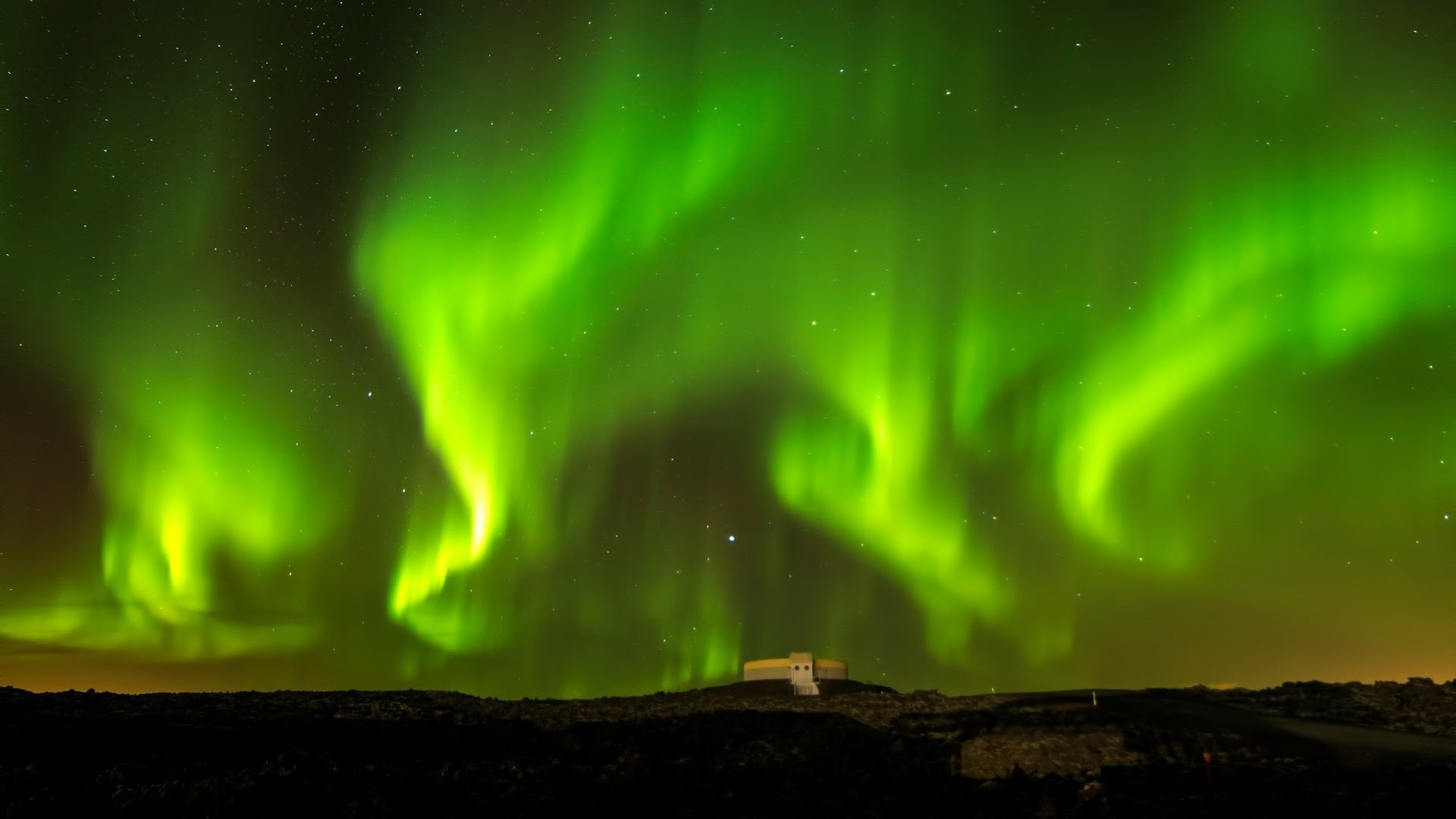 Aurora Borealis over a building and landscape HD Wallpaper