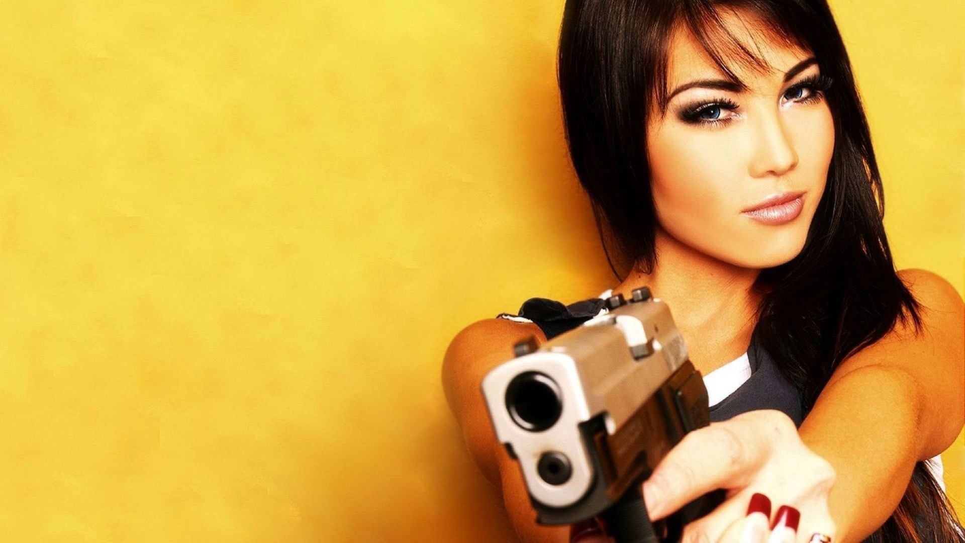 Woman holding a pistol in front of a yellow background HD Wallpaper