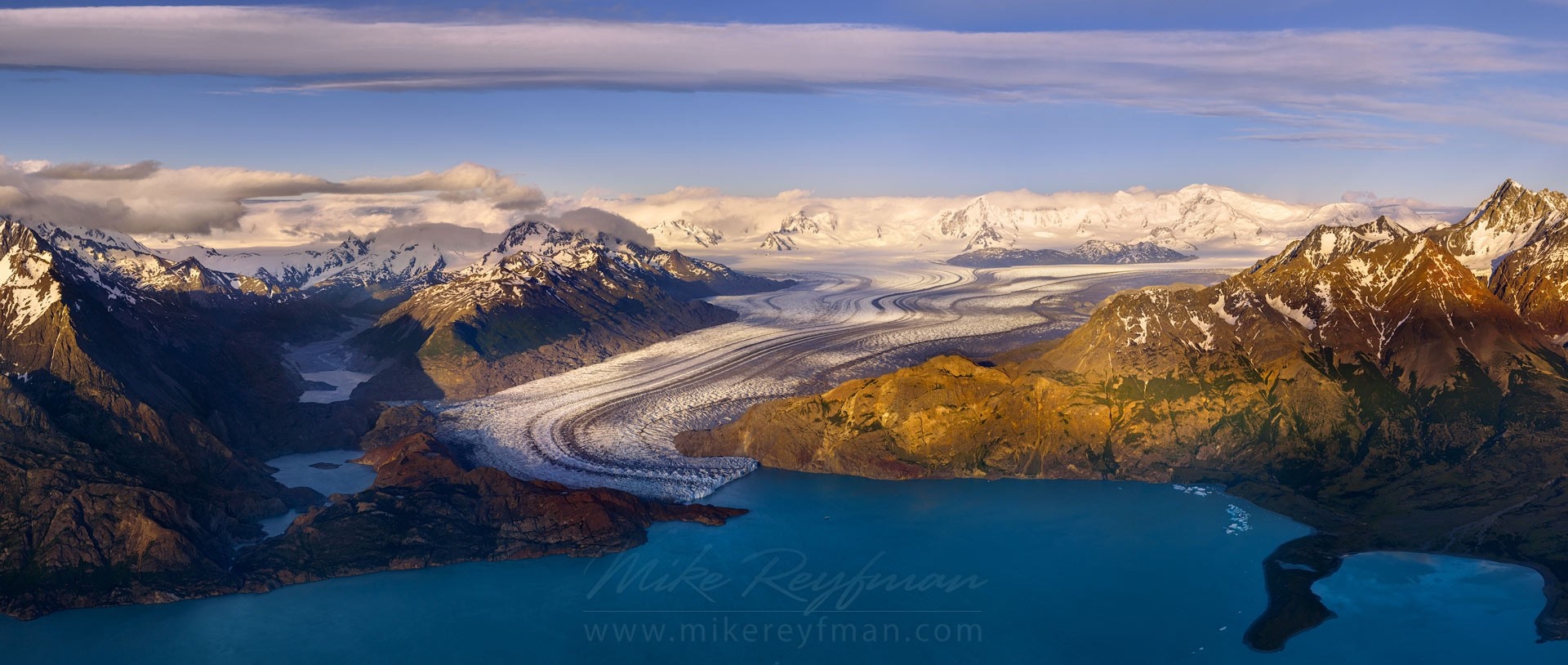 Glacier flowing into a turquoise lake surrounded by mountains HD Wallpaper