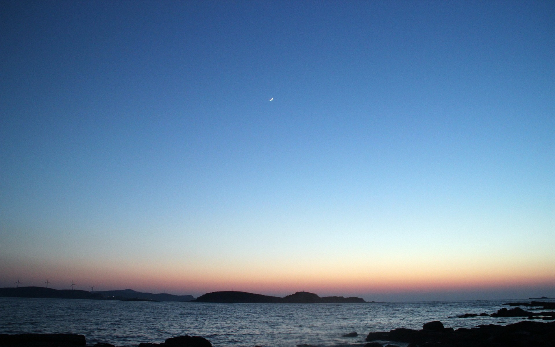 Crescent moon over the sea at dusk with islands and wind turbines HD Wallpaper
