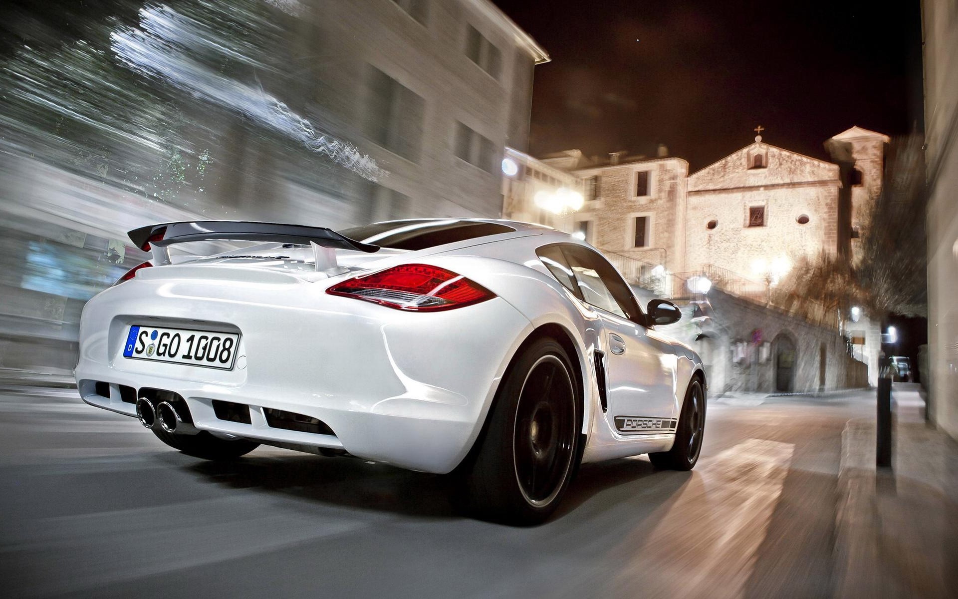 White Porsche Cayman driving on a street at night HD Wallpaper