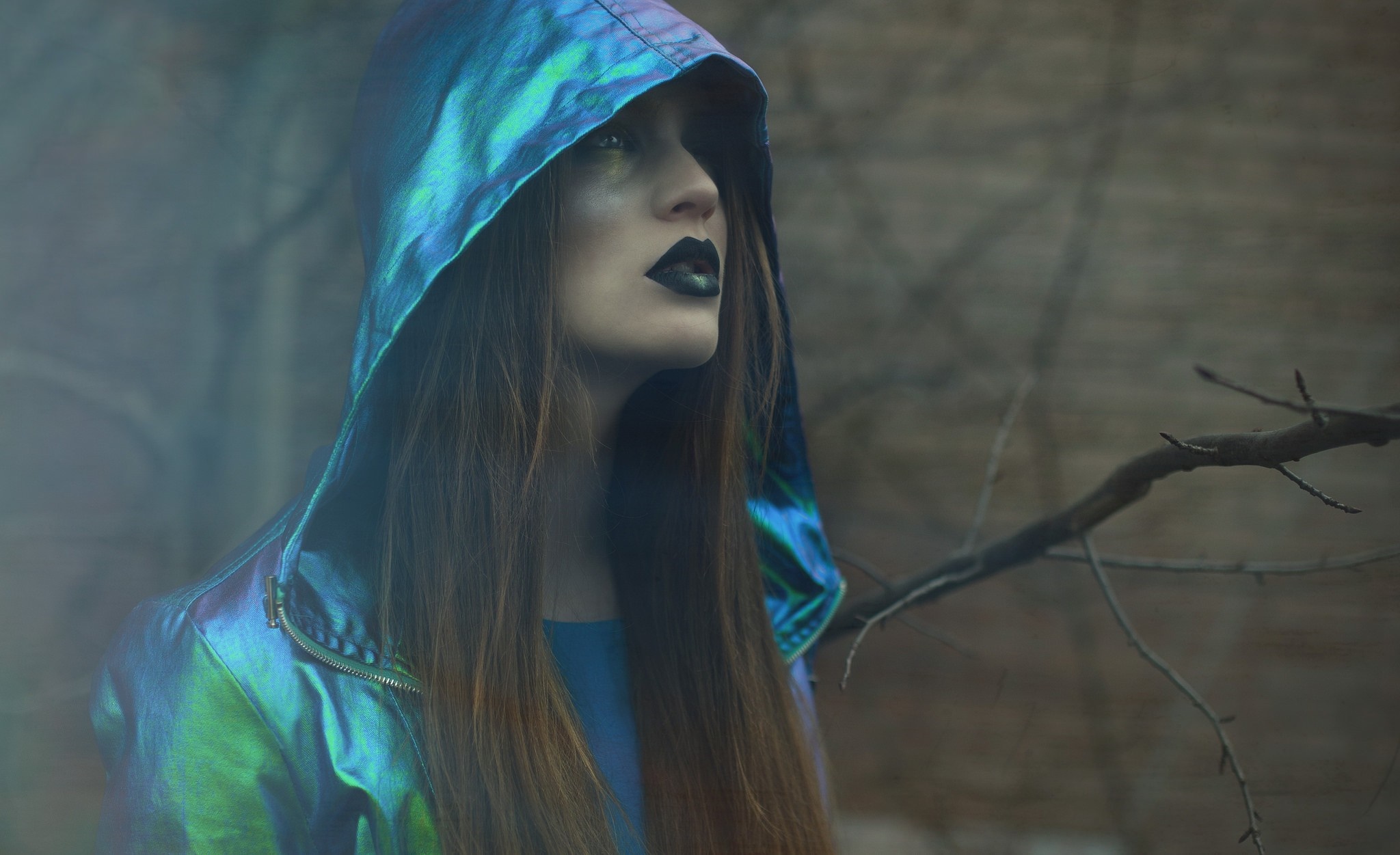 Woman in iridescent hooded jacket with dark makeup HD Wallpaper