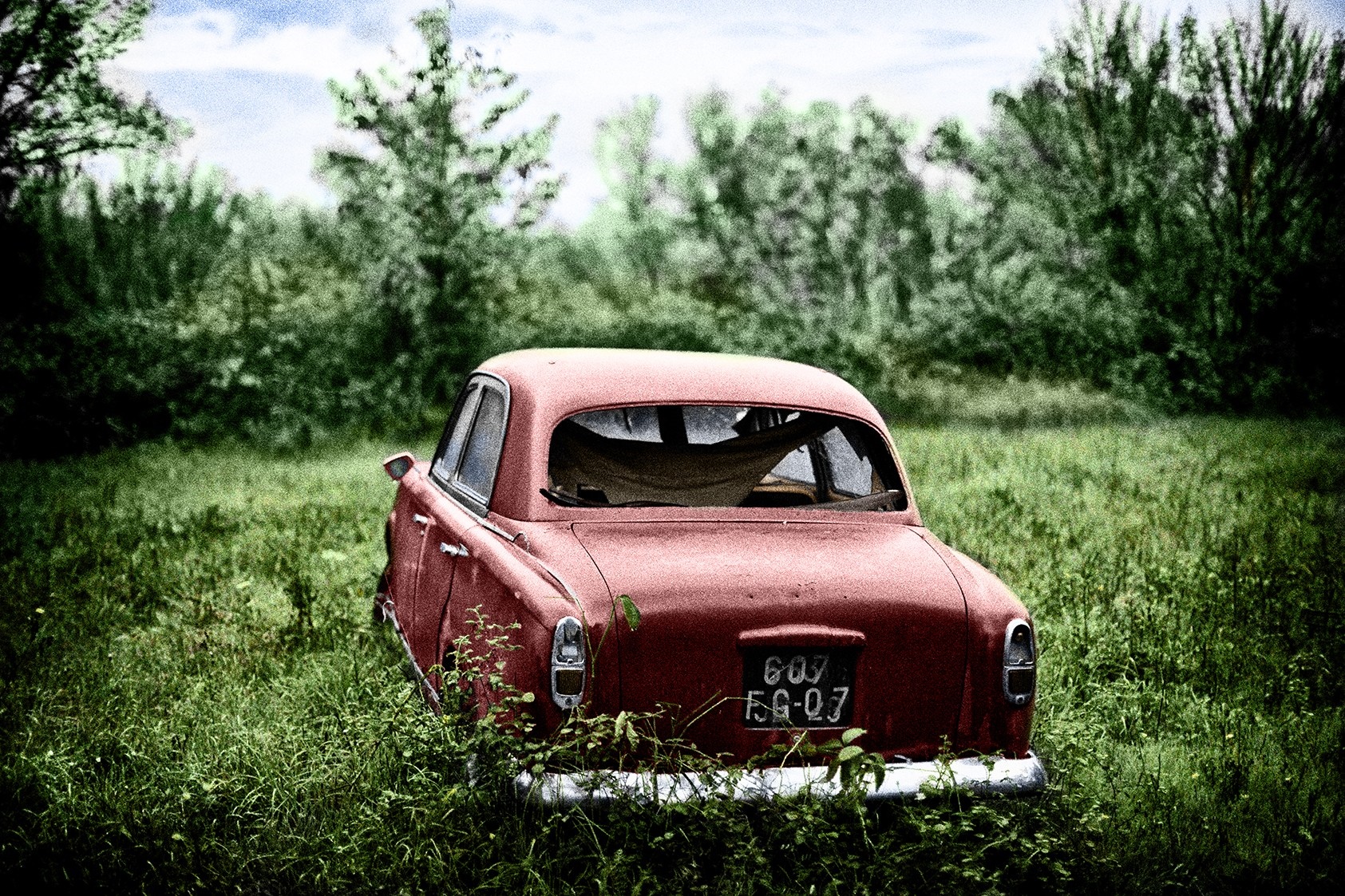Abandoned red vintage car in a grassy field HD Wallpaper