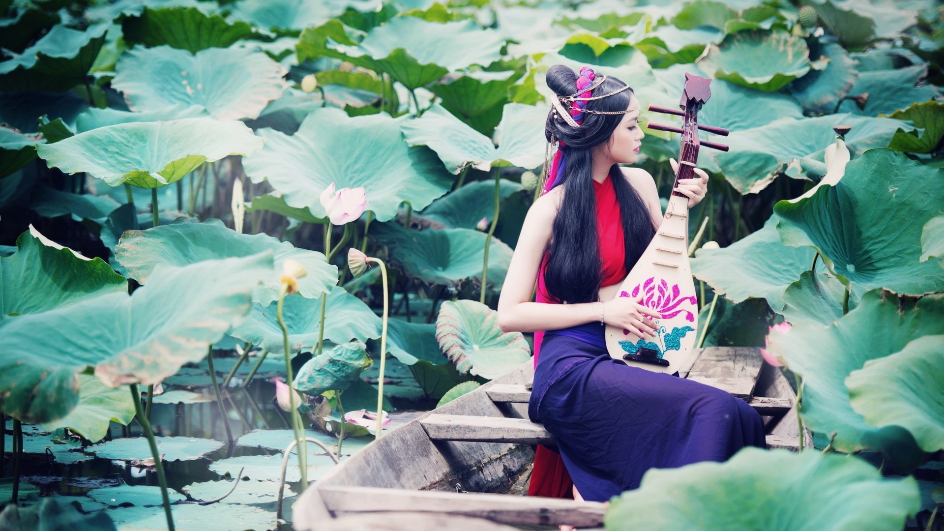 Woman playing a lute in a boat surrounded by lotus leaves HD Wallpaper