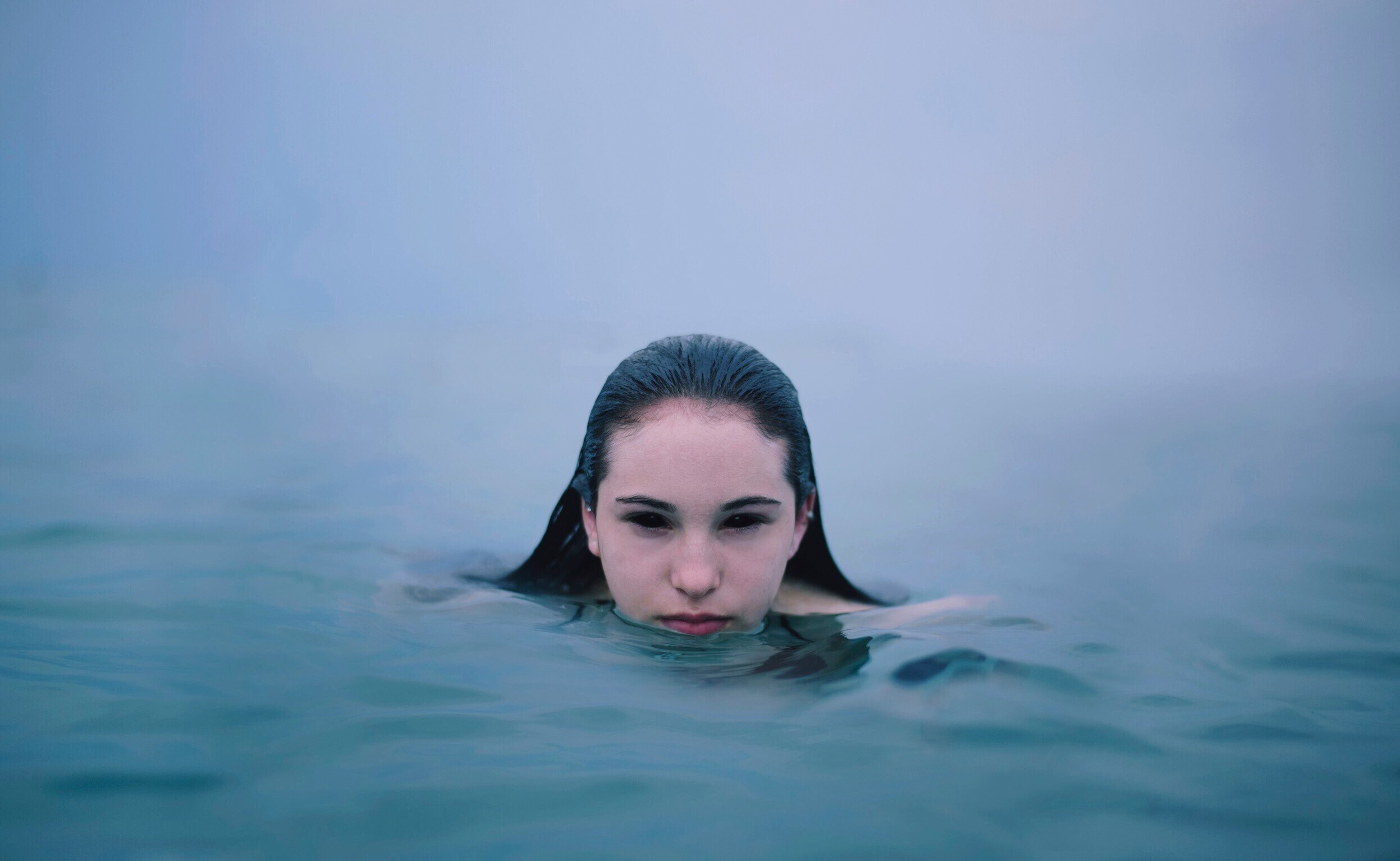 Woman with dark eyes in the sea HD Wallpaper