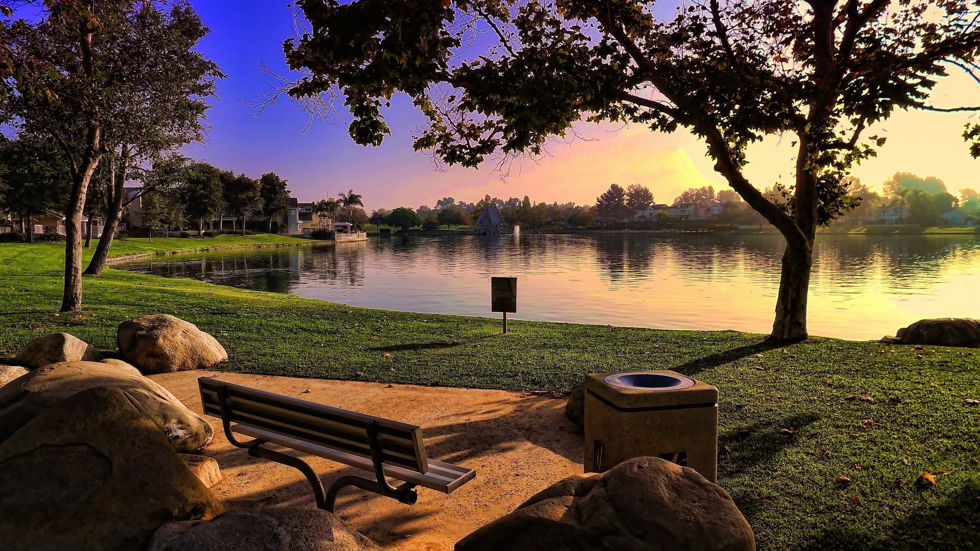 Park bench by a lake at sunset HD Wallpaper
