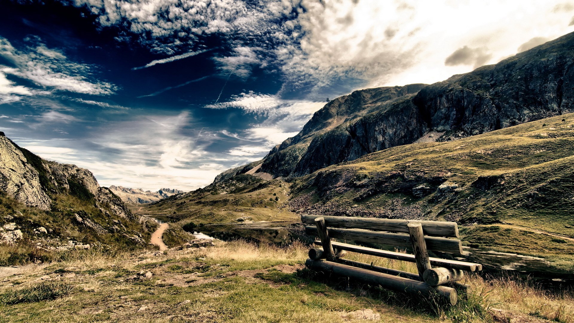 Wooden bench overlooking a mountain valley with a lake HD Wallpaper