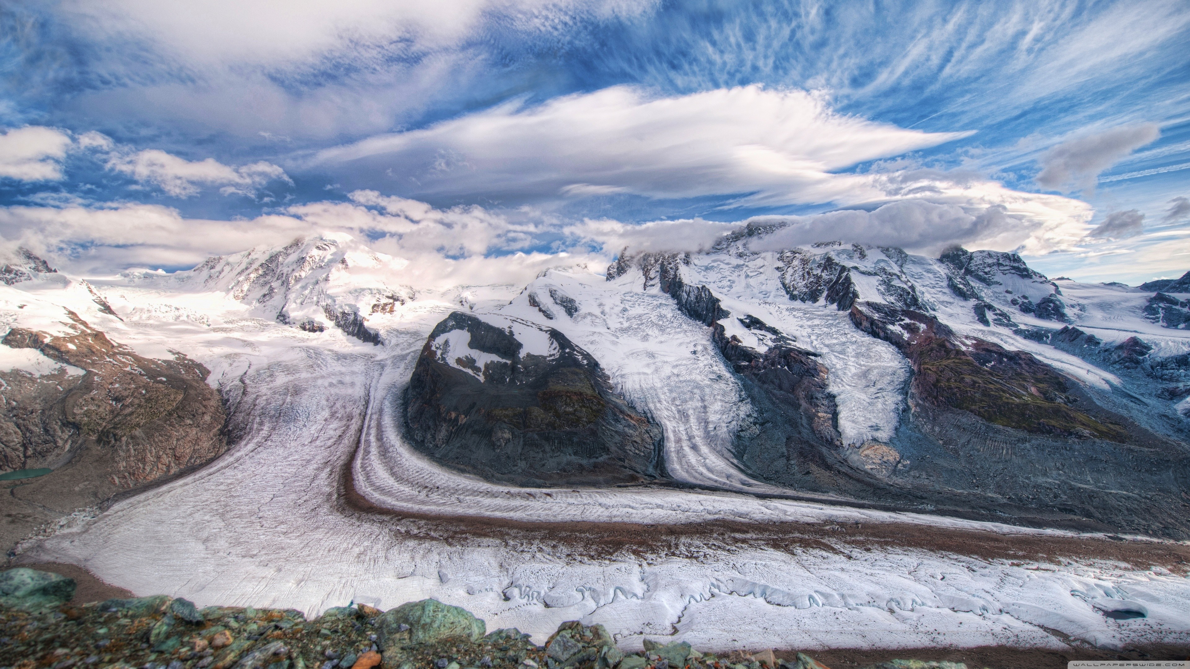 Snow-covered mountains and glaciers under a cloudy sky HD Wallpaper