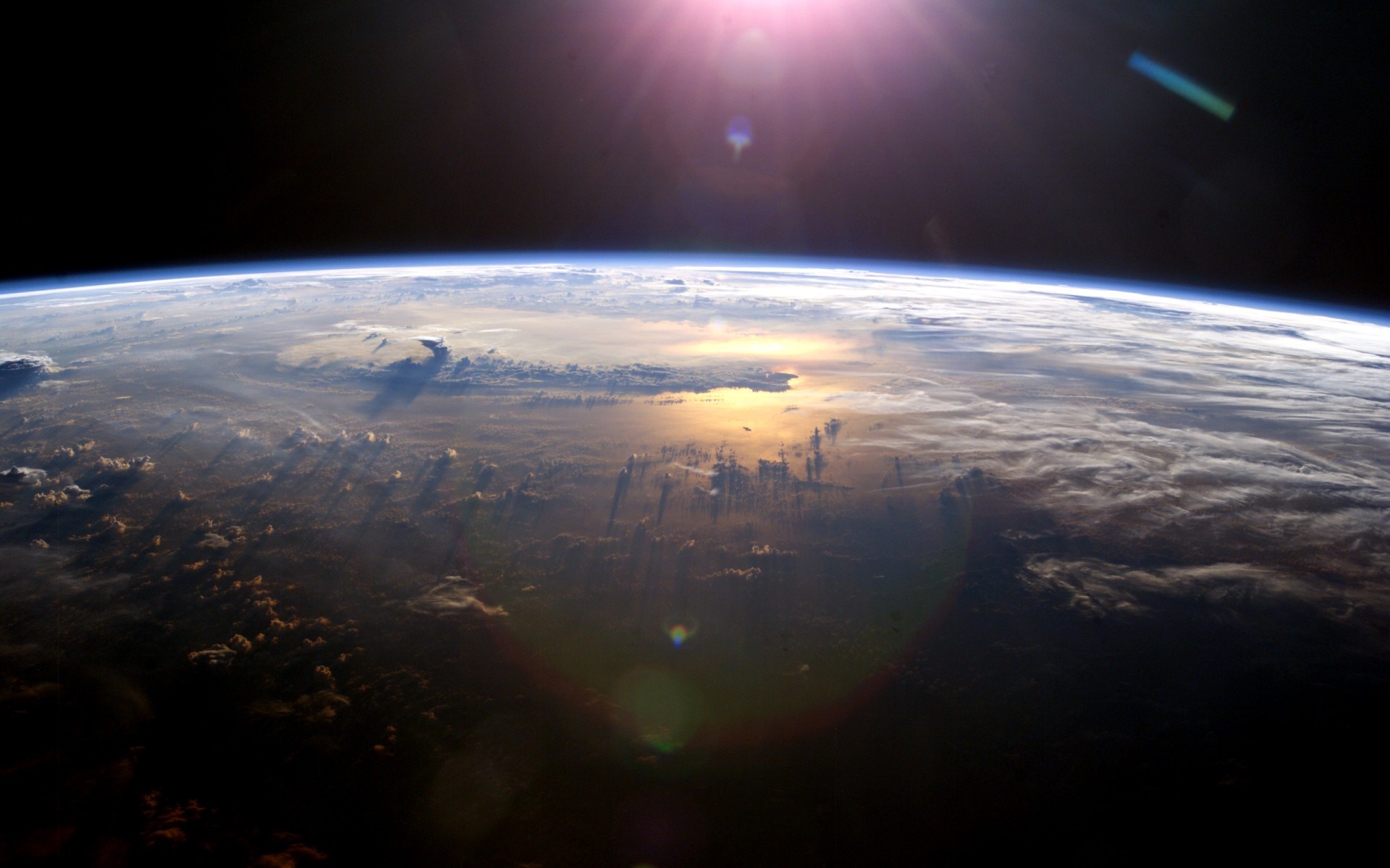 Earth's atmosphere and sunlit ocean from space HD Wallpaper