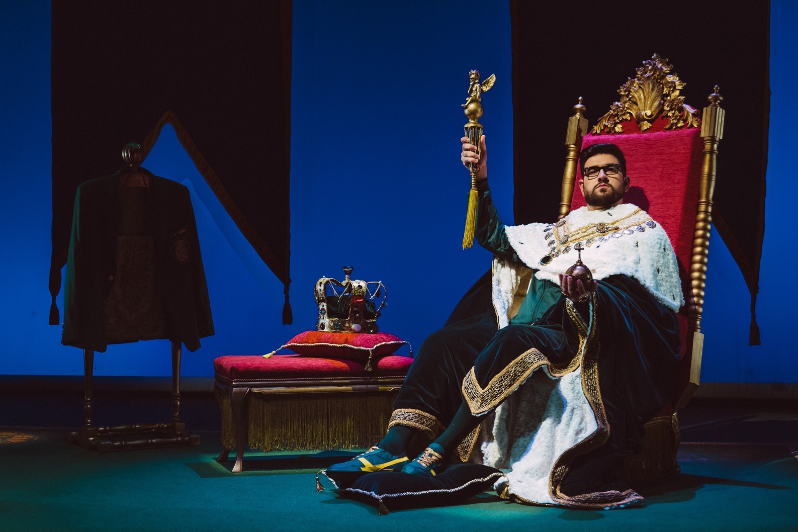 Man in royal attire on a throne with scepter and crown HD Wallpaper