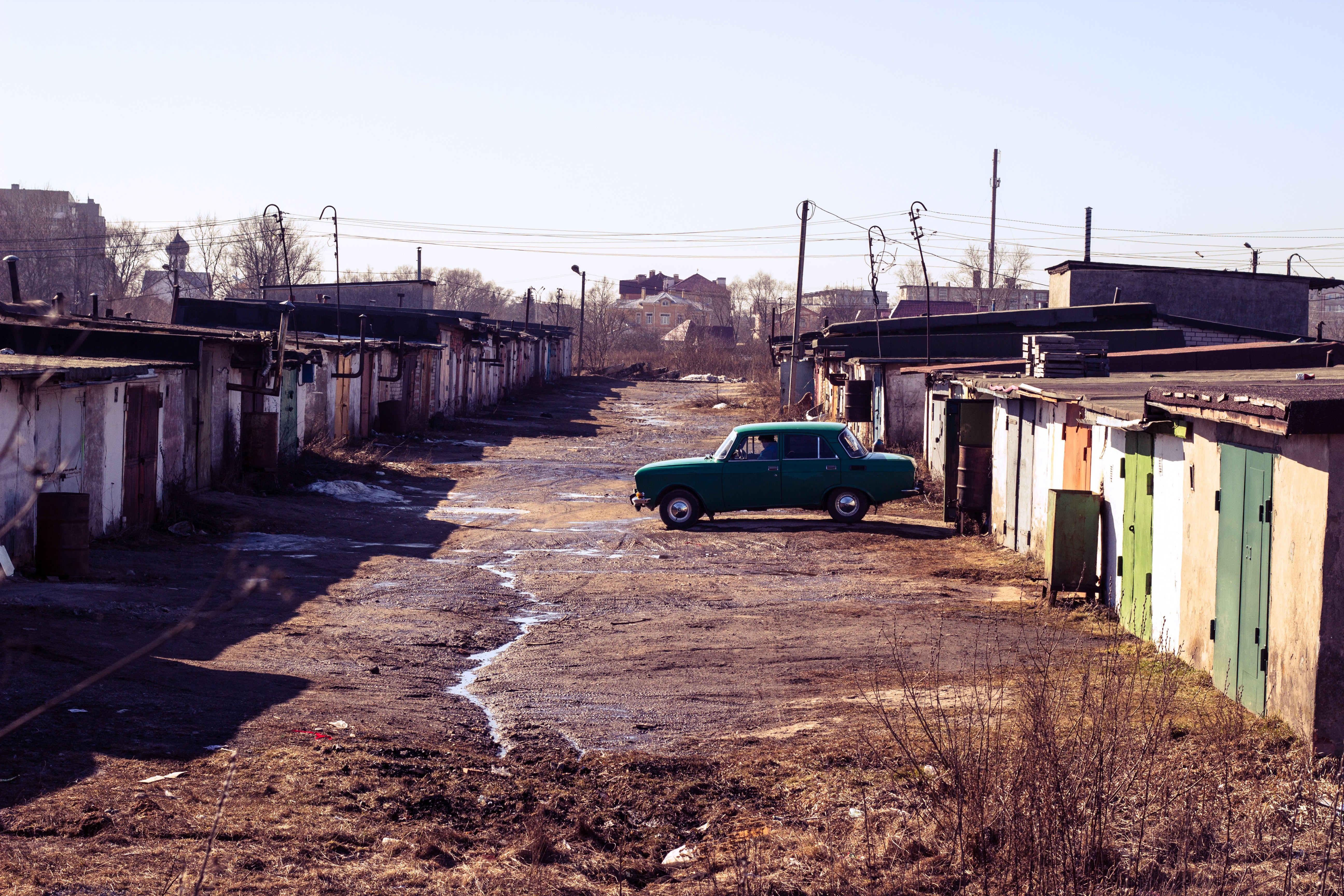 Green Moskvich car parked in a row of garages HD Wallpaper