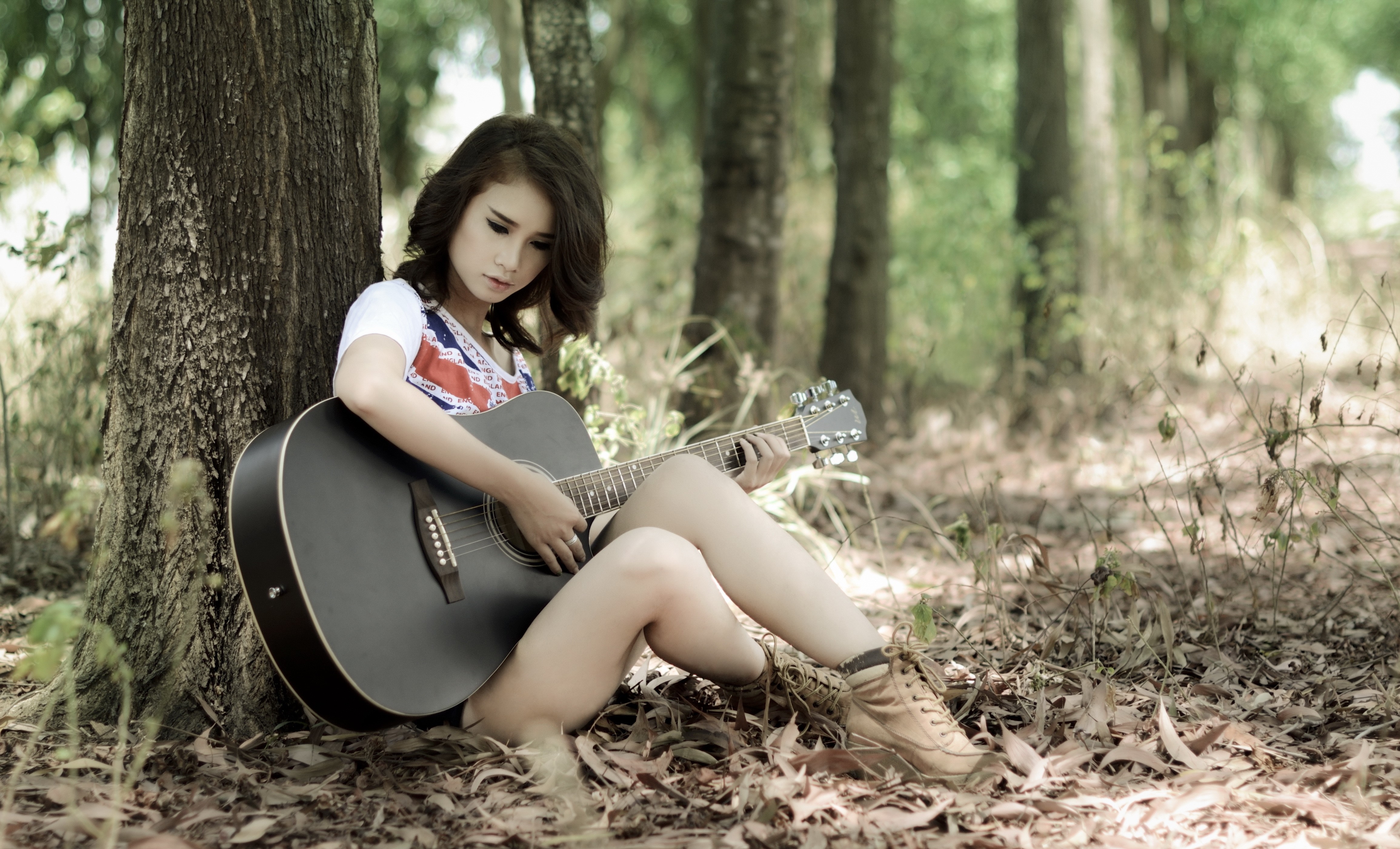 Woman playing guitar in a forest HD Wallpaper