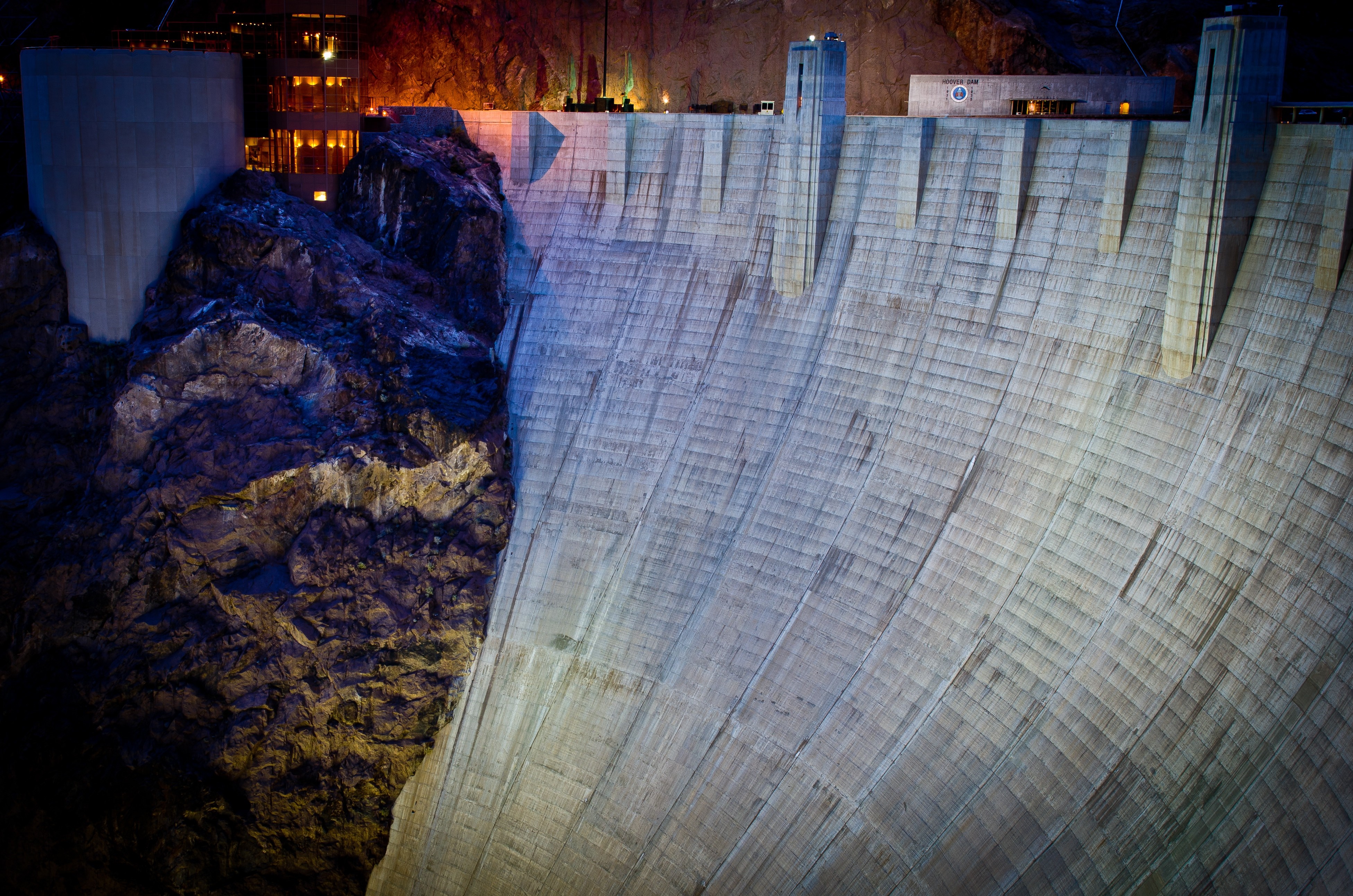 Hoover Dam at night with rock formations HD Wallpaper