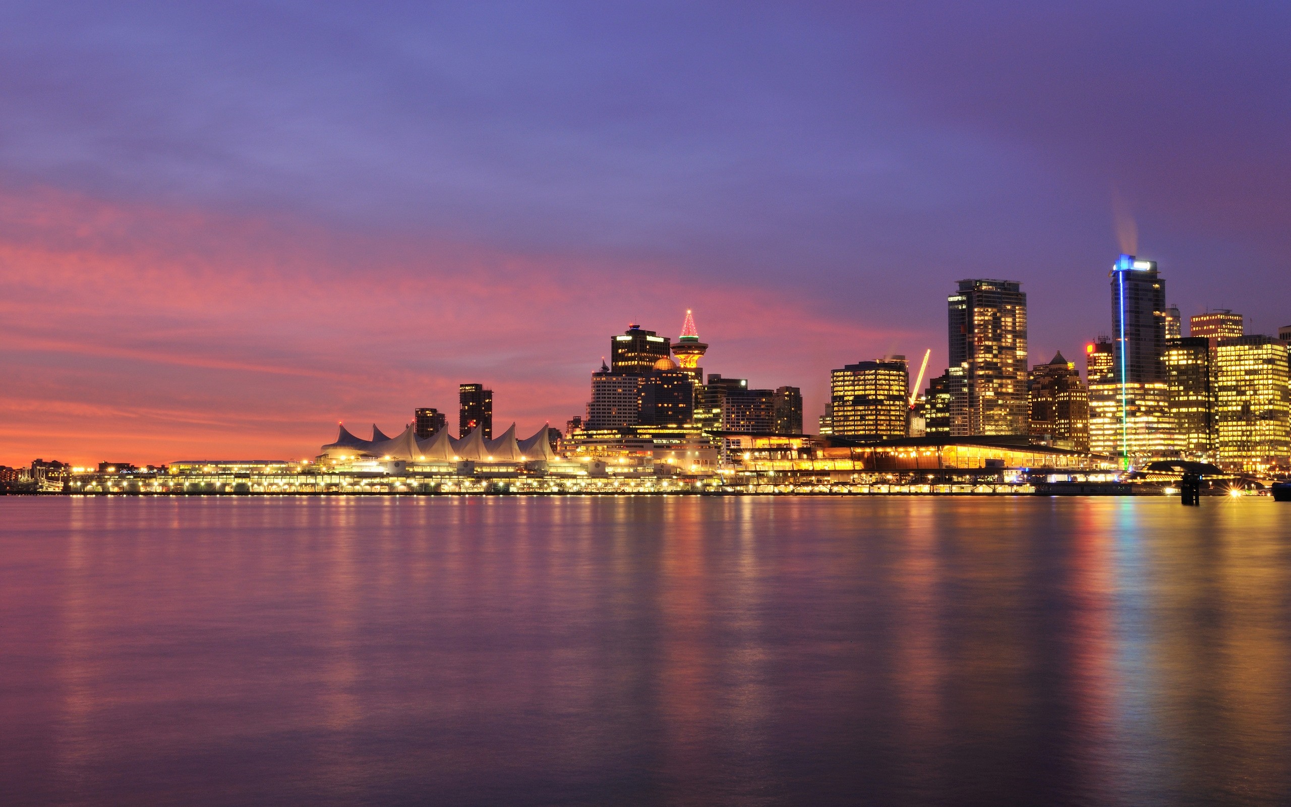 Vancouver cityscape at dusk with illuminated buildings and water reflection HD Wallpaper
