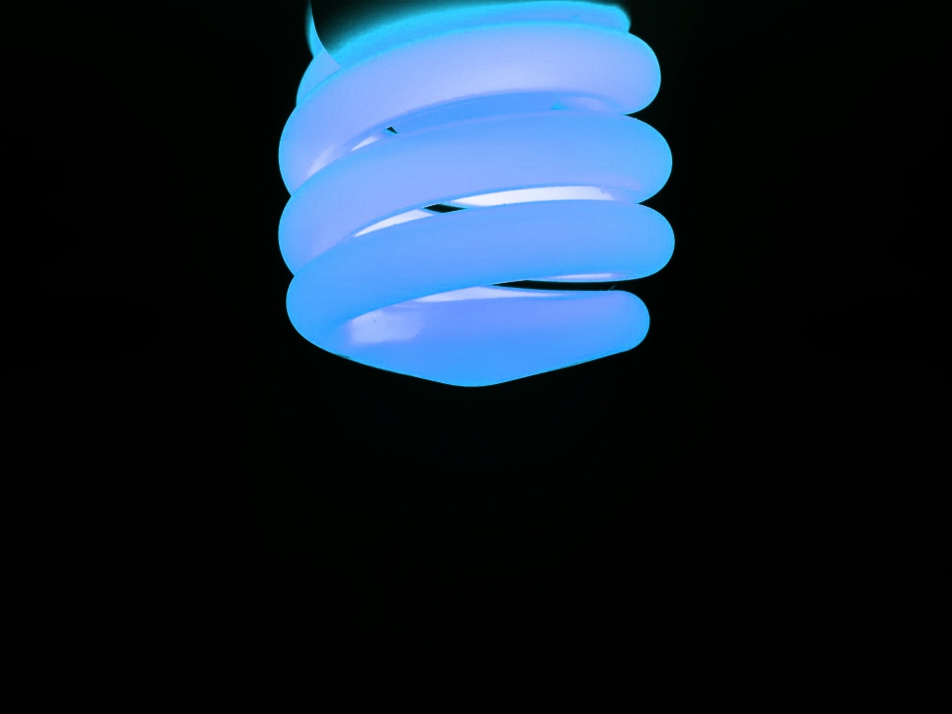 Close-up of a blue spiral light bulb HD Wallpaper