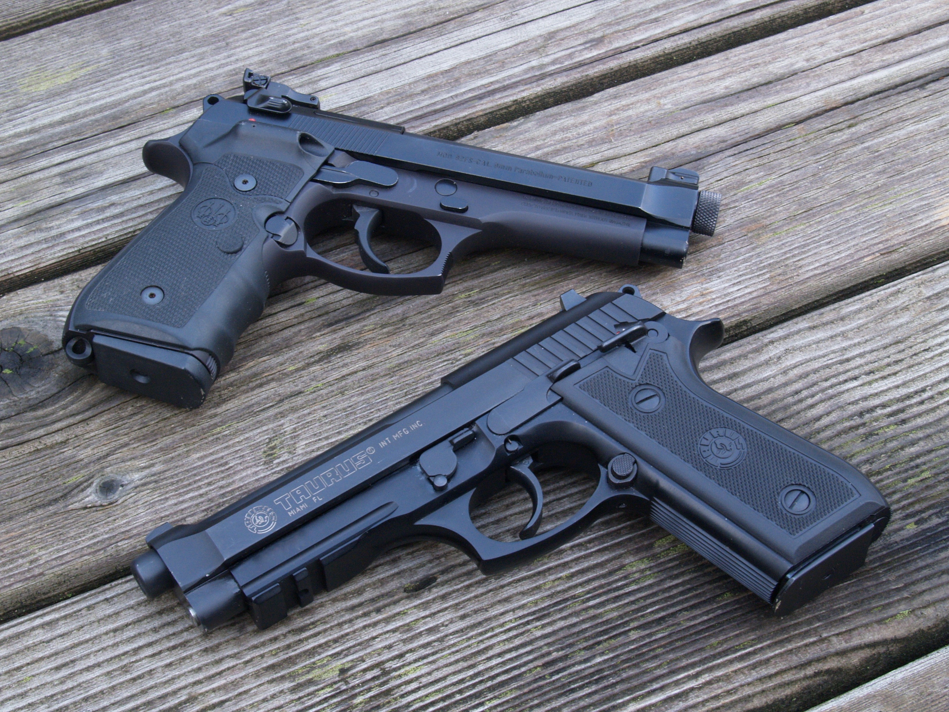 Two handguns on a wooden surface HD Wallpaper