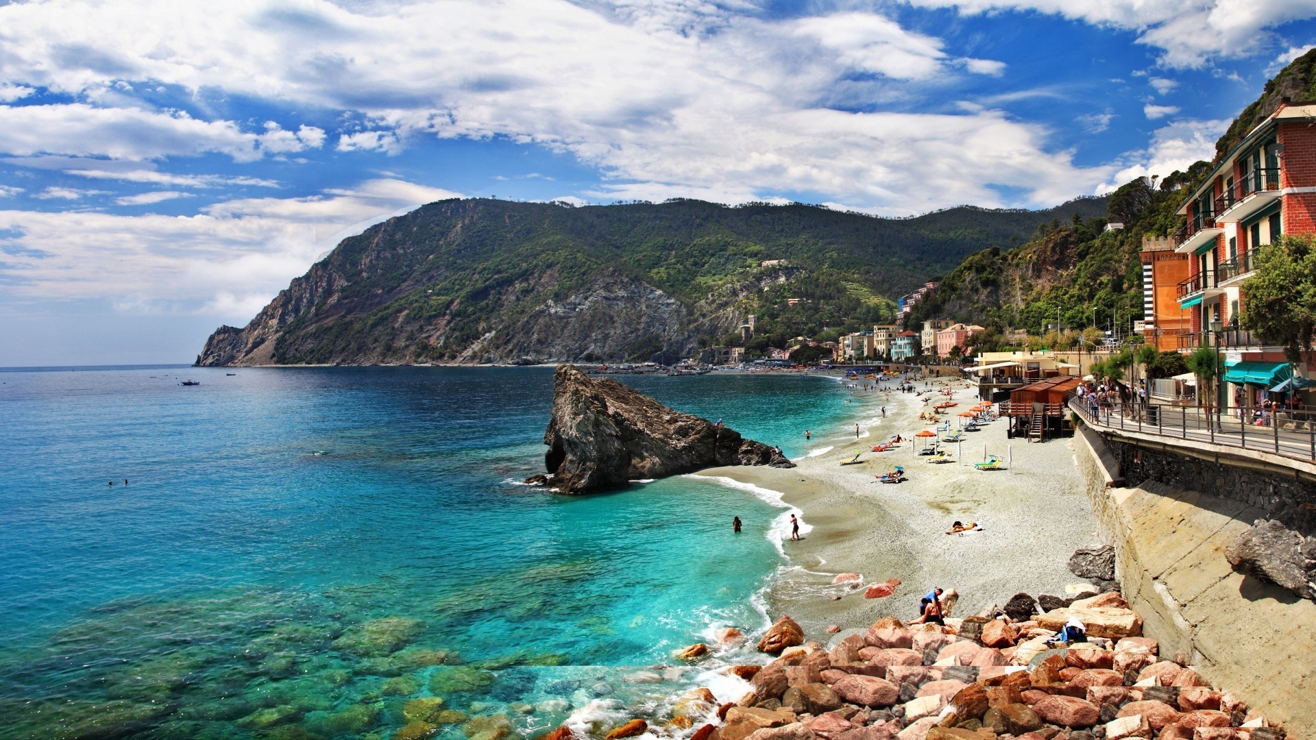 Coastal town with beach and rocky mountain overlooking the sea HD Wallpaper