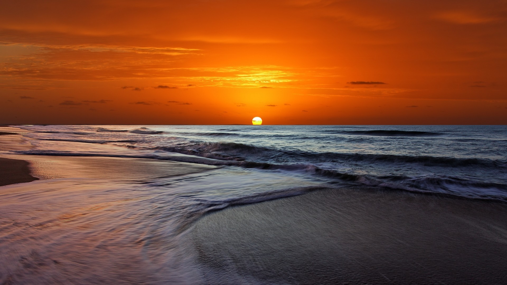 Sunset over the ocean with waves on the shore HD Wallpaper