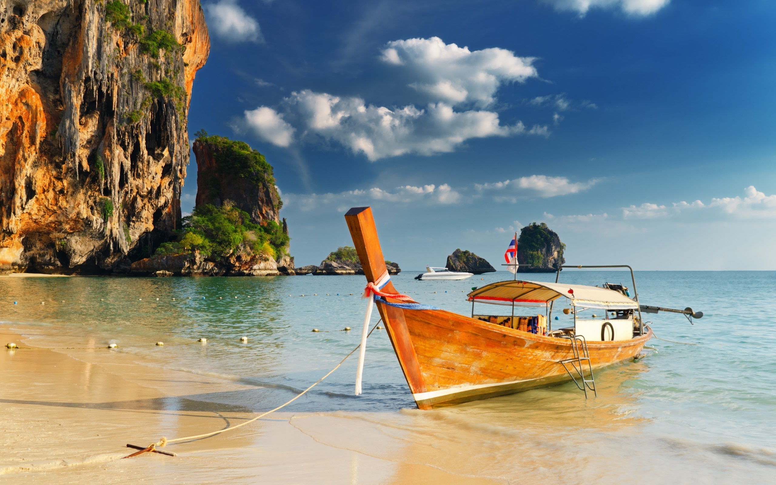Long tail boat on a tropical beach with limestone cliffs HD Wallpaper