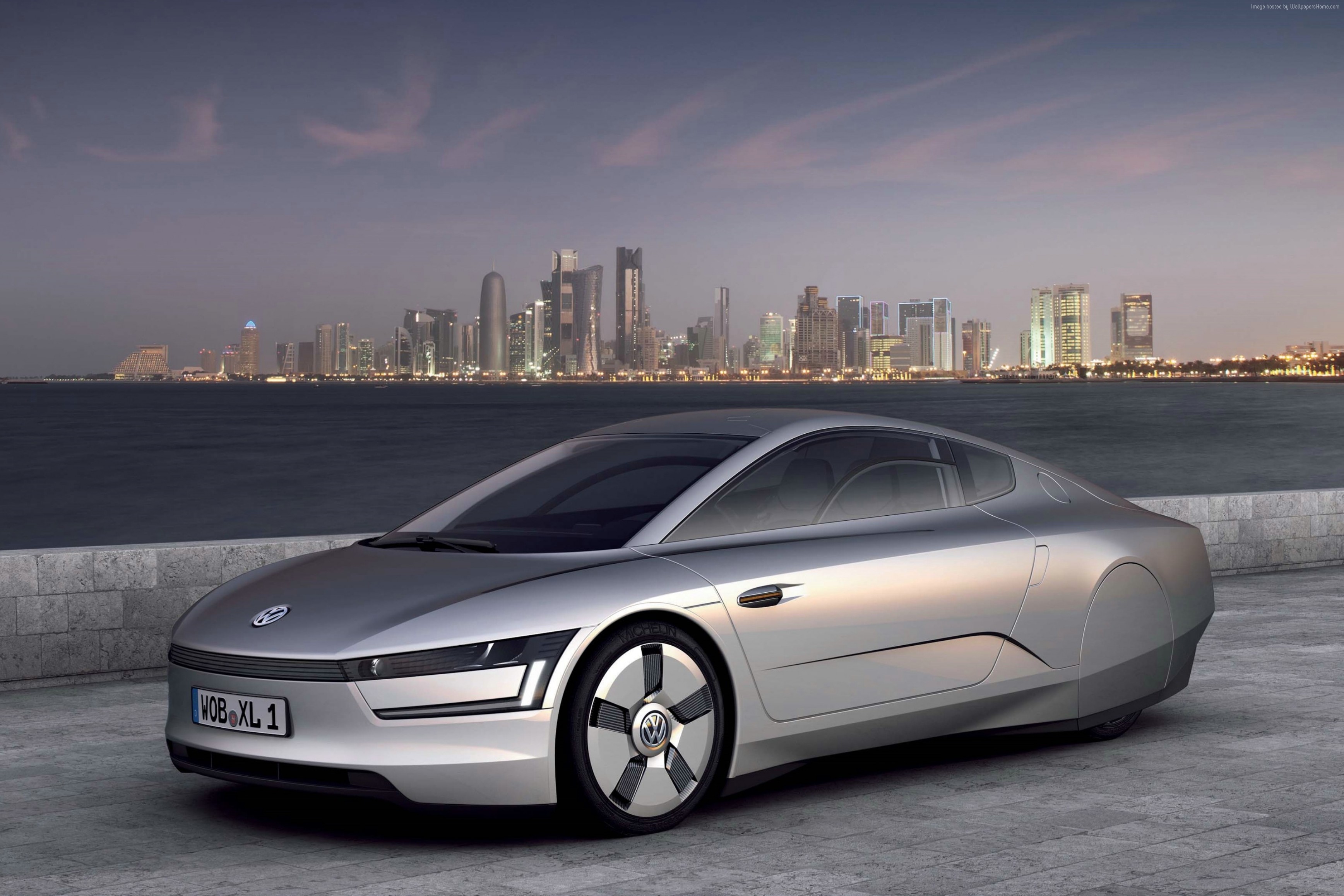 Volkswagen XL1 hybrid car in front of a city skyline HD Wallpaper