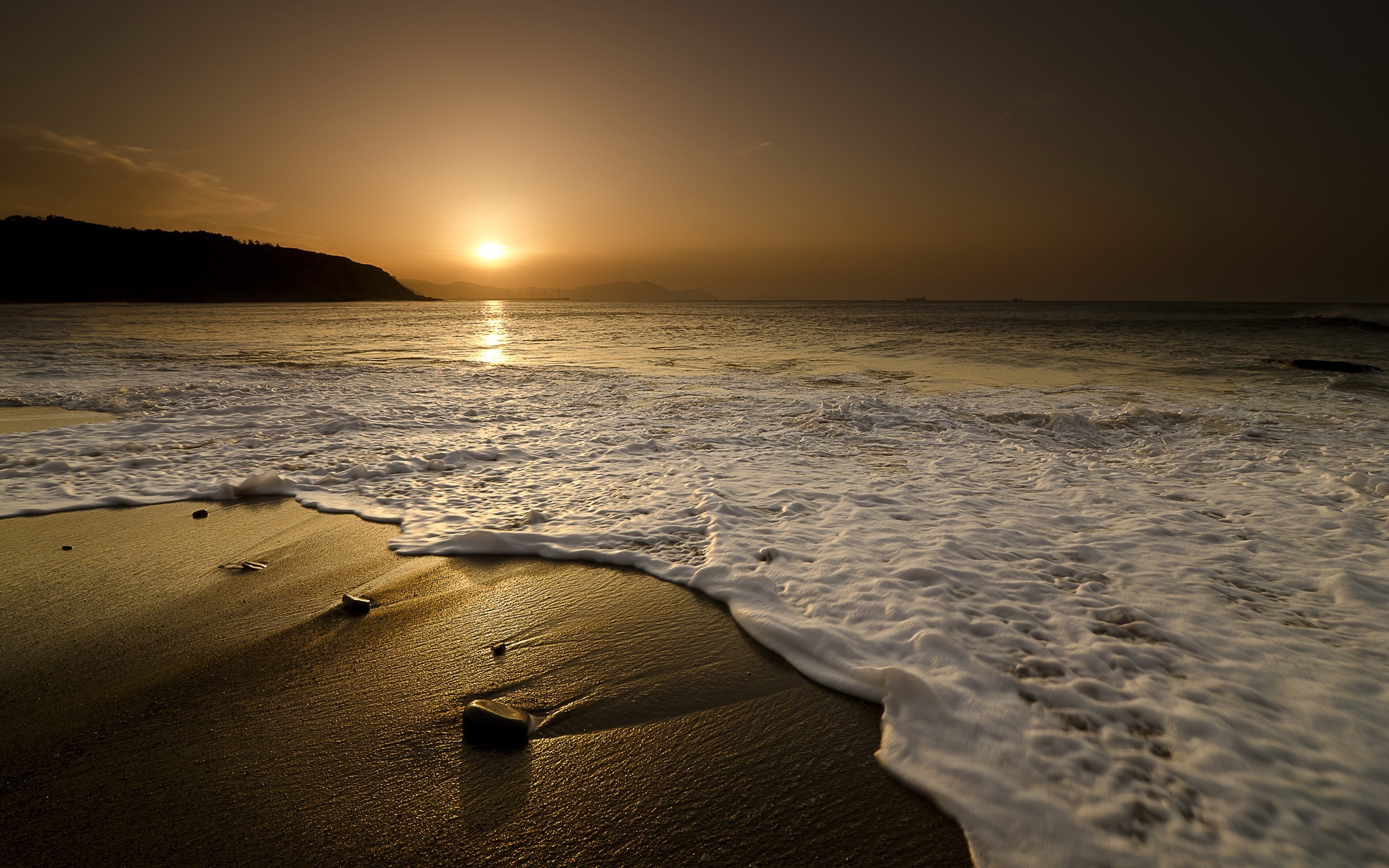 Sunset over the ocean with waves on the shore HD Wallpaper