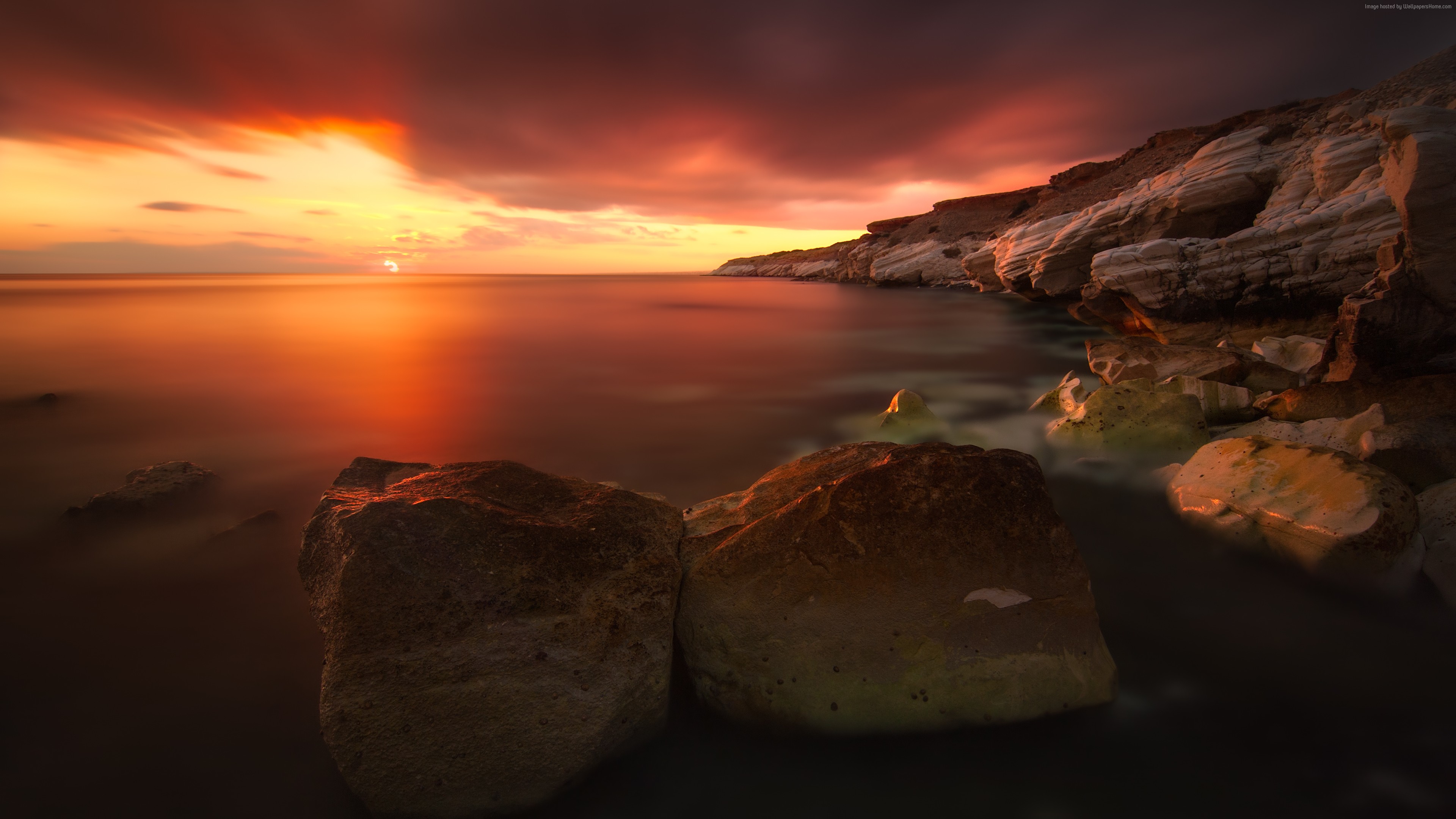 Sunset over the ocean with rocky coastline HD Wallpaper