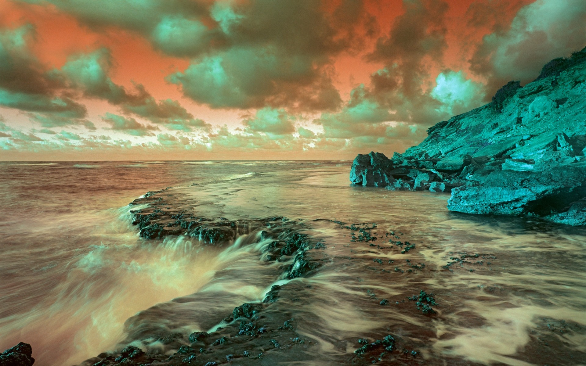 Ocean waves crashing on a rocky coast under a dramatic sky HD Wallpaper