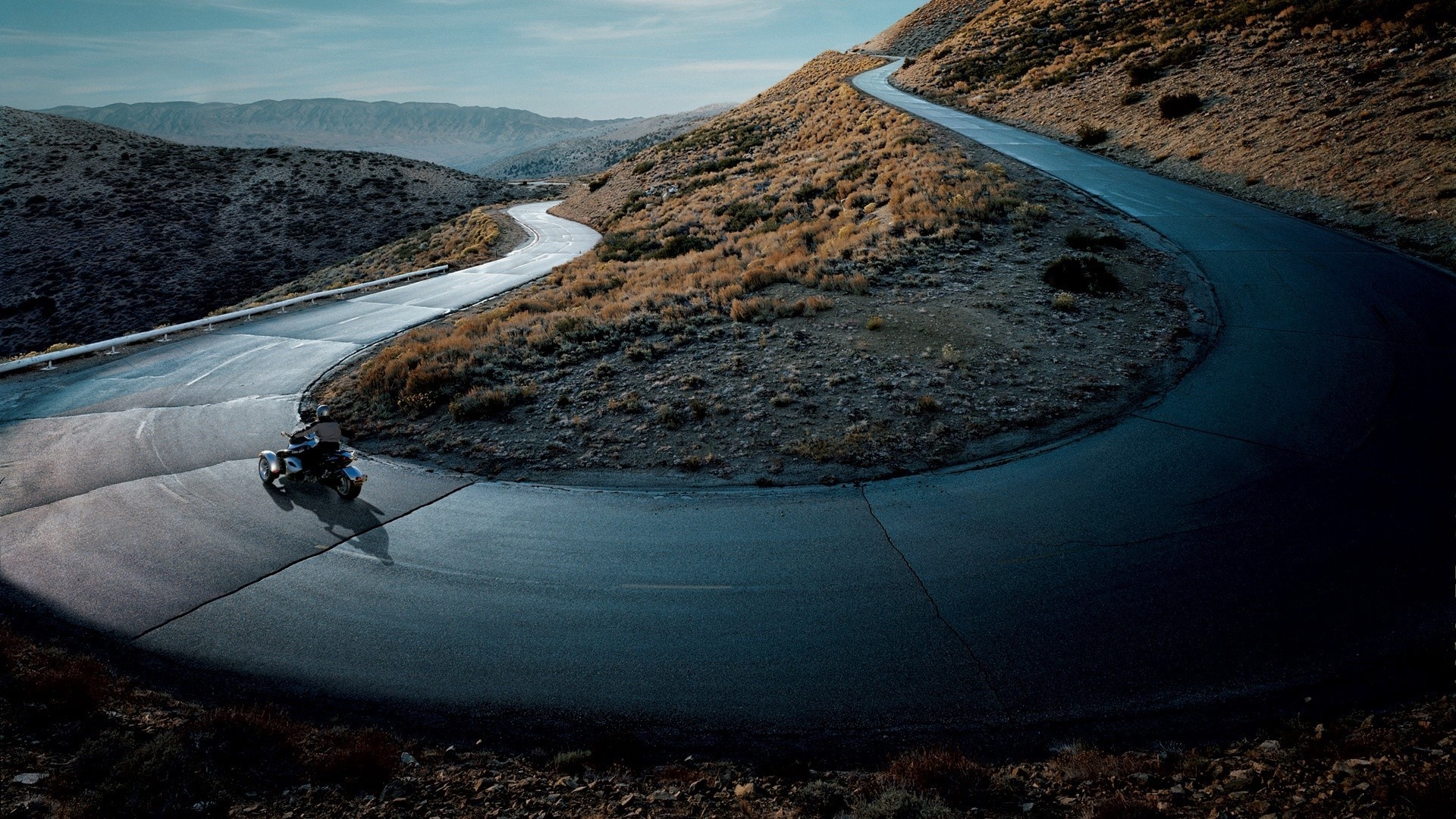 Motorcycle on a winding mountain road HD Wallpaper