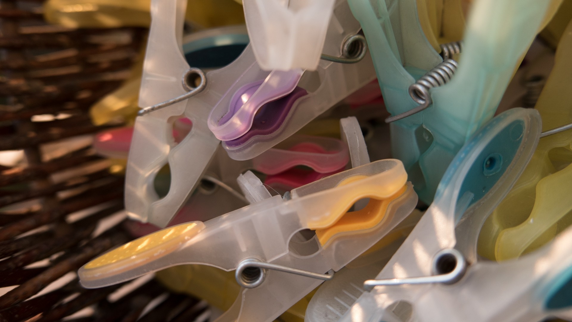 Close up of colorful clothespins in a basket HD Wallpaper