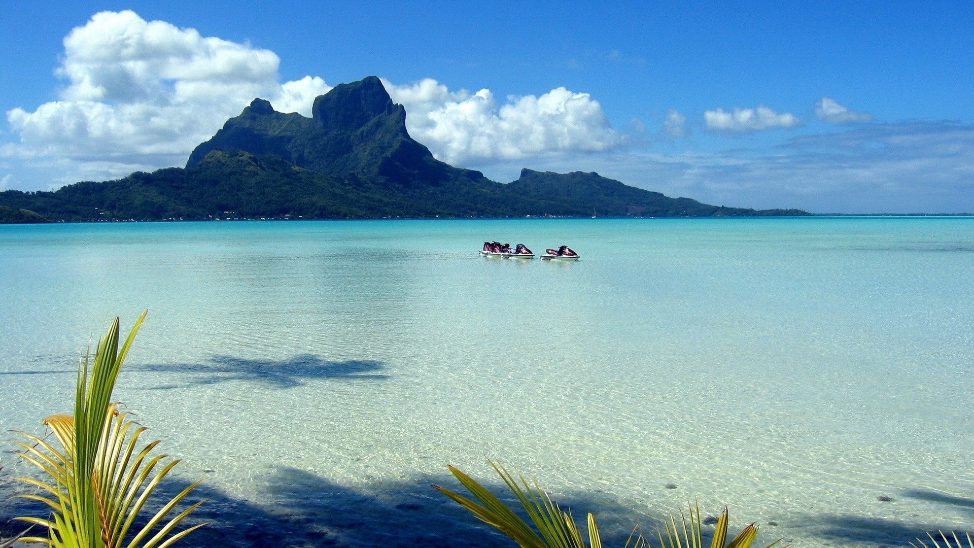 Jet skis in a tropical lagoon with a mountain island HD Wallpaper