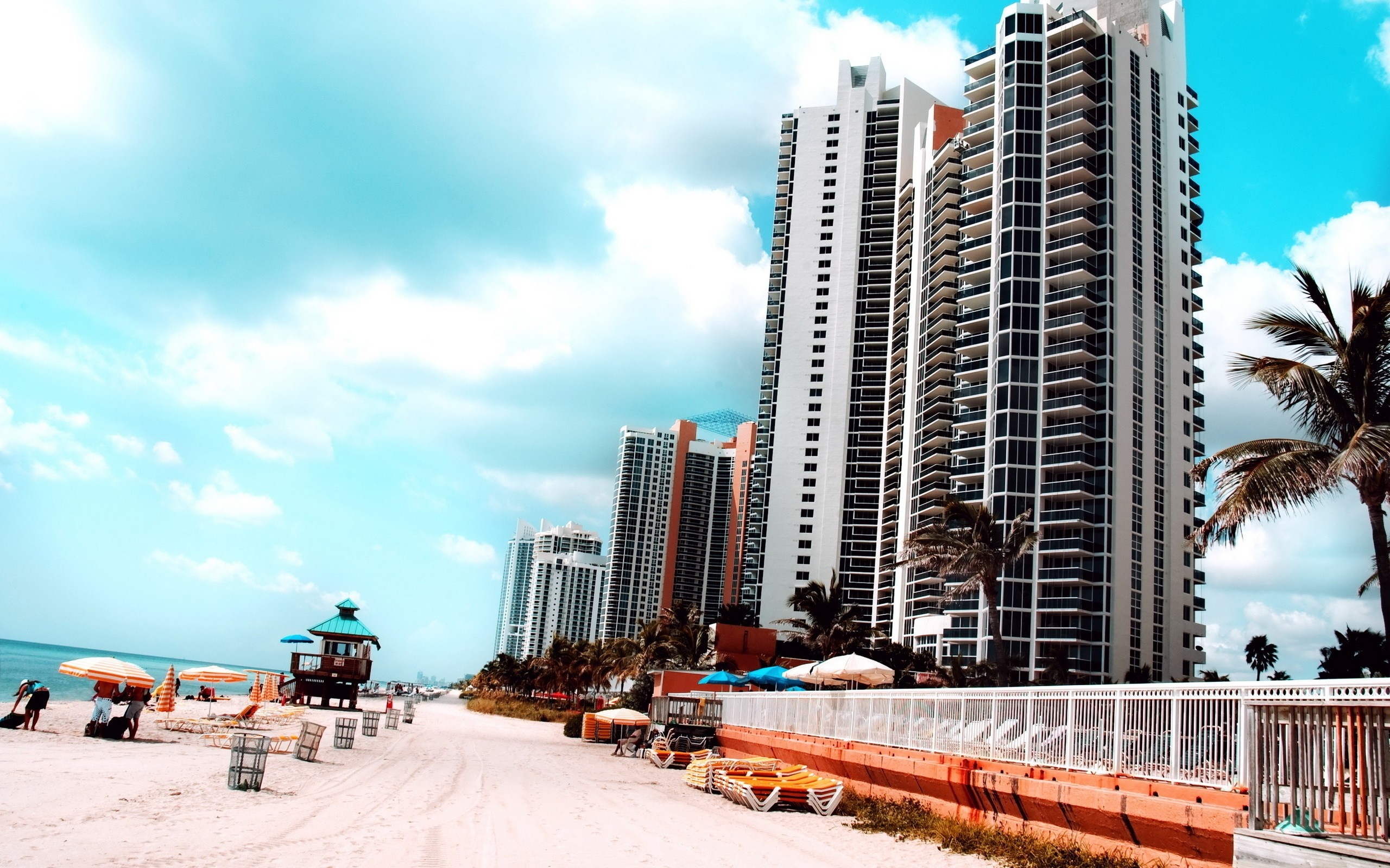 Beachfront high-rise buildings and a lifeguard tower on a sunny day HD Wallpaper