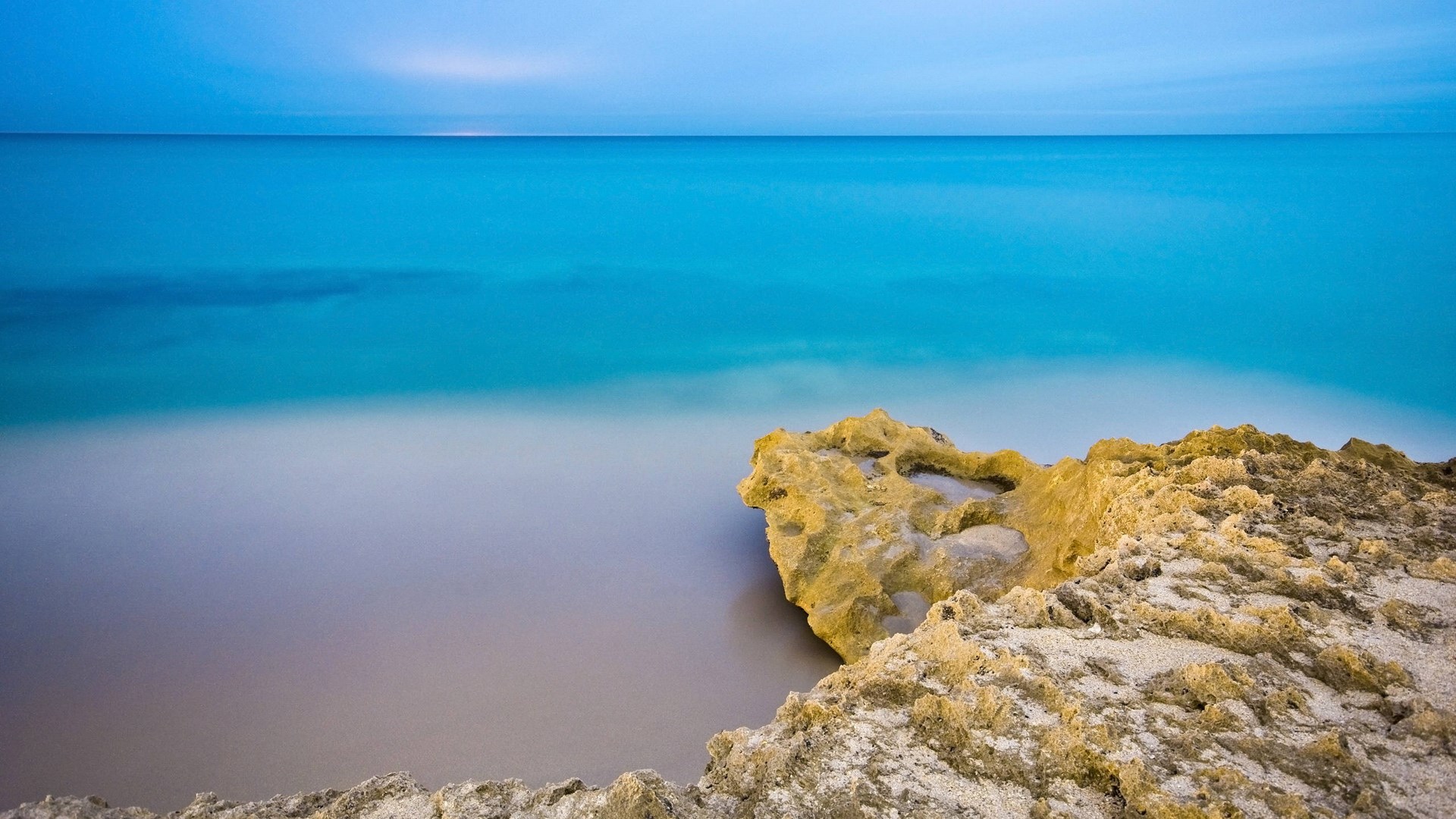 Ocean and rocky shore at dusk HD Wallpaper