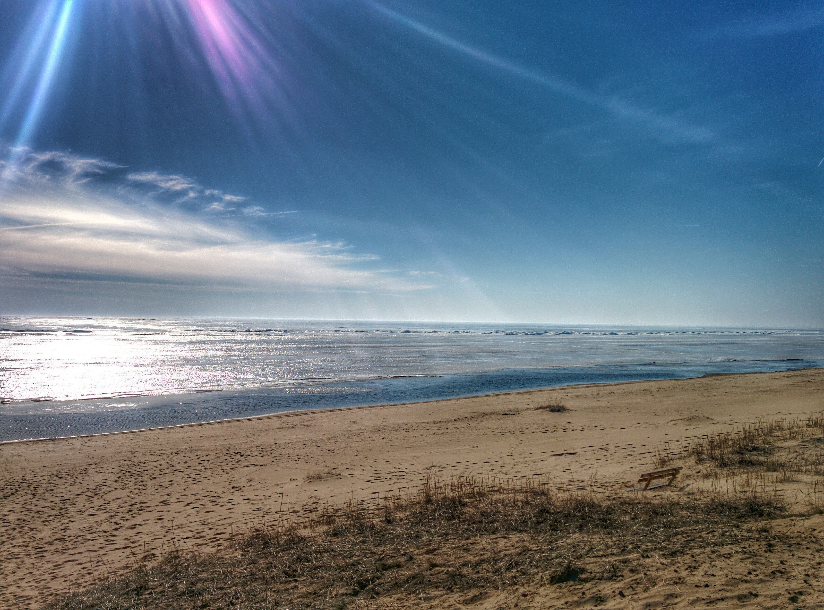 Beach with sand, ocean, and sky with sun rays HD Wallpaper