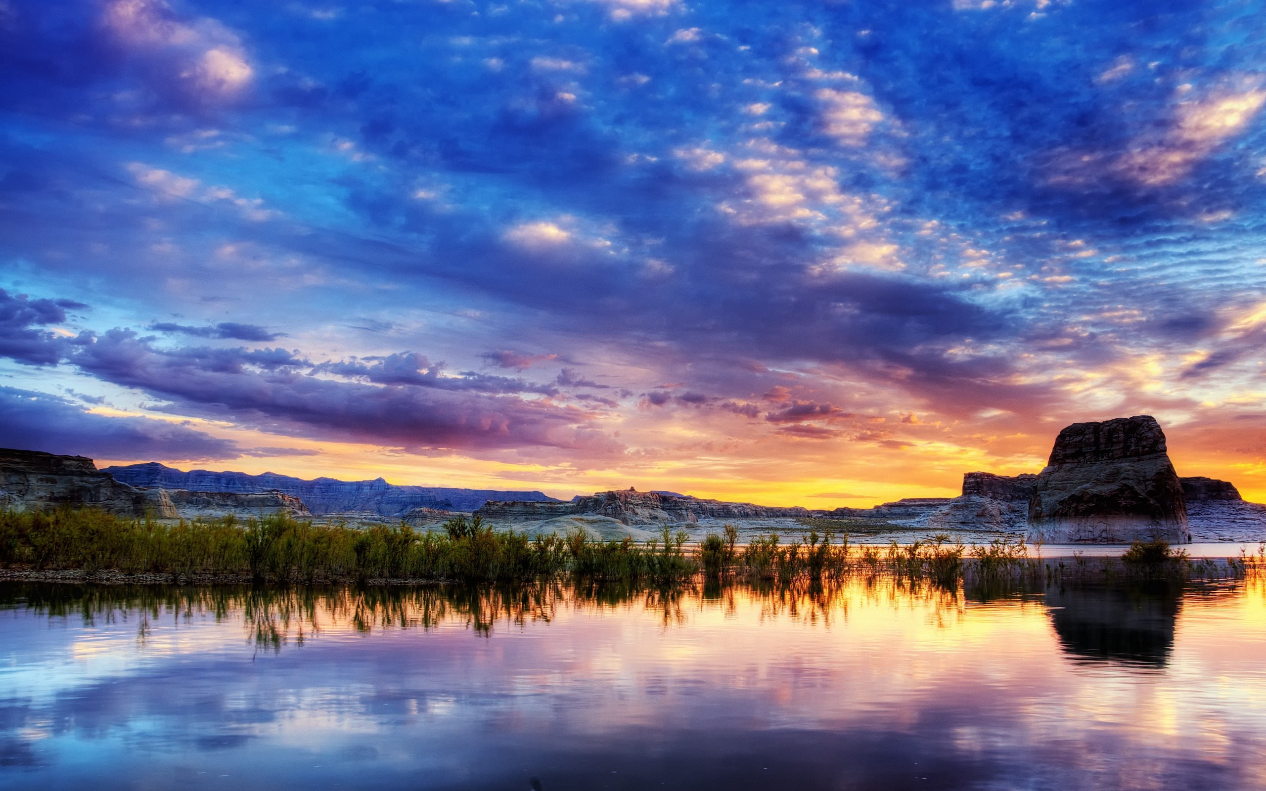 Sunset over a calm lake with mountains and clouds HD Wallpaper
