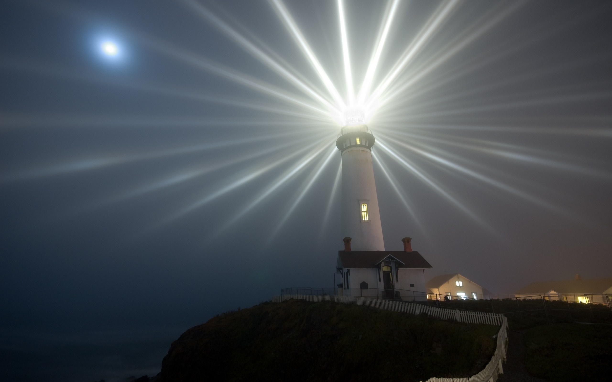 Lighthouse beam cutting through fog with moonlight HD Wallpaper