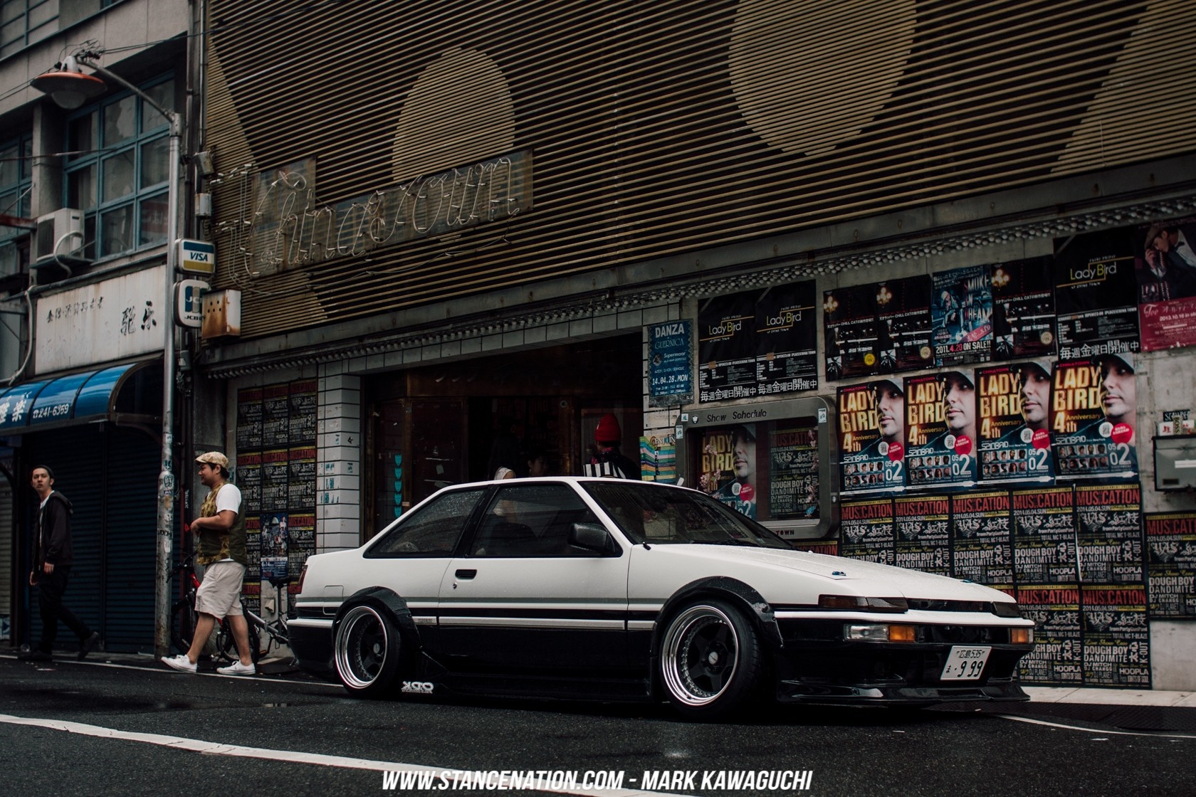 White and black Toyota AE86 parked on a street in Japan HD Wallpaper