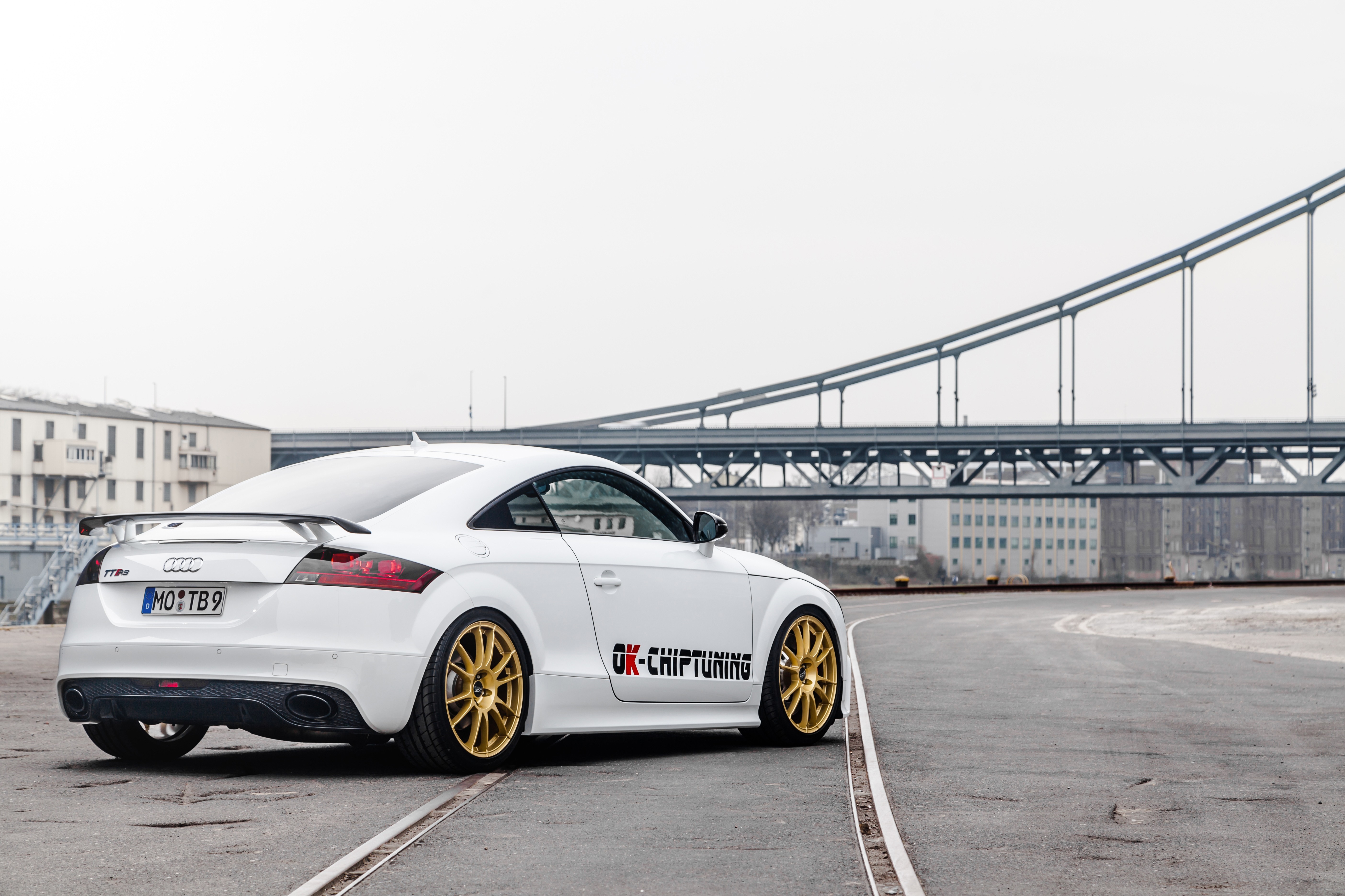 White Audi TT RS with gold wheels and bridge in background HD Wallpaper