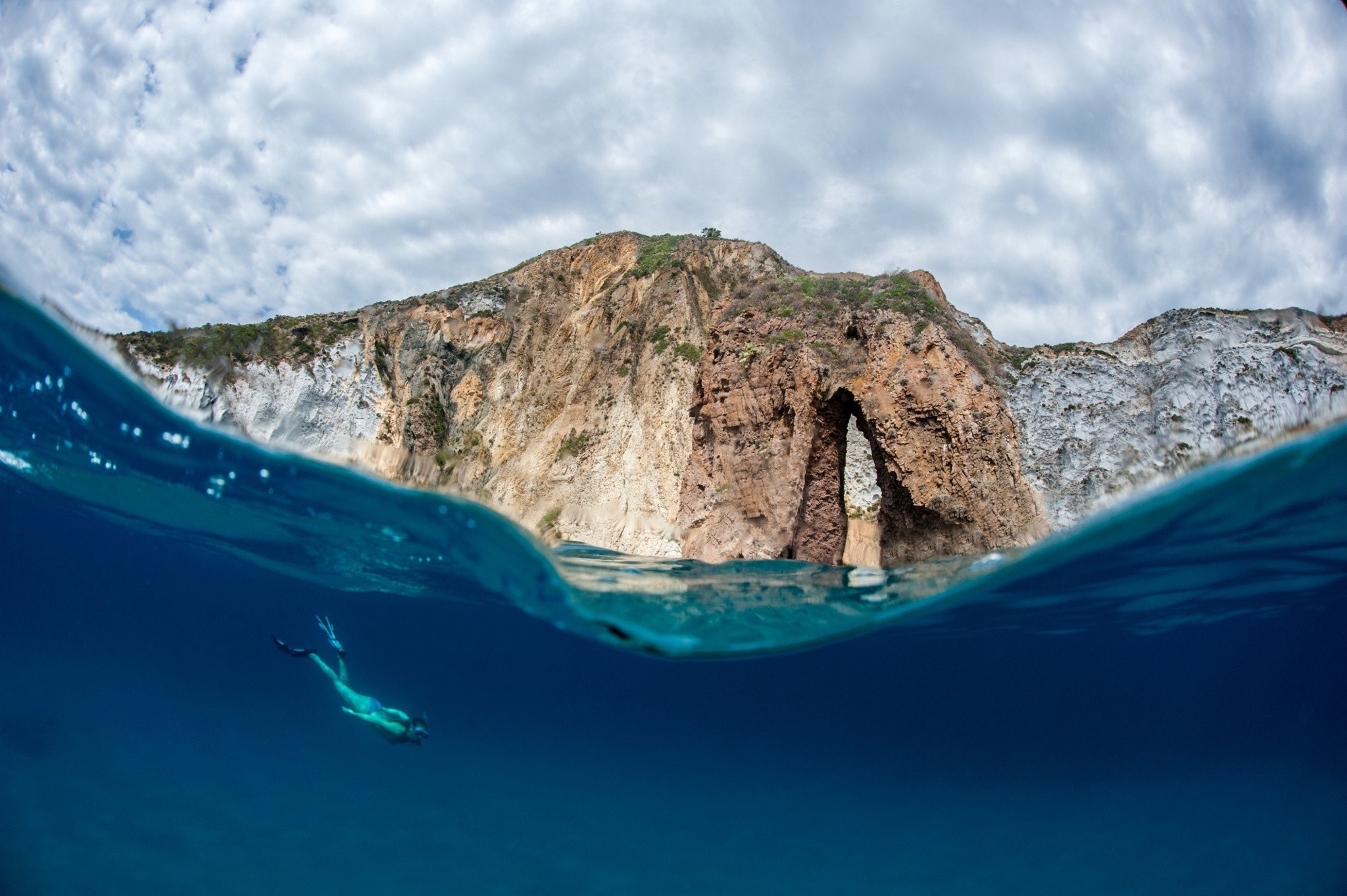 Split view of a diver and a rocky archway in the sea HD Wallpaper