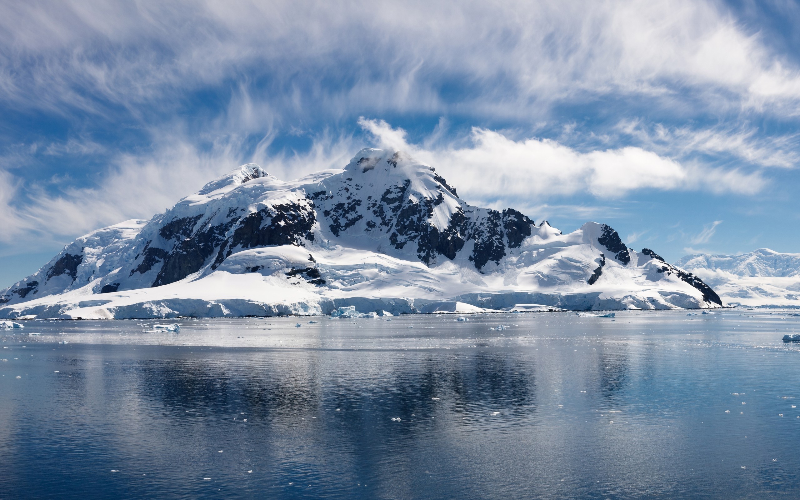 Snow-covered mountains reflected in the sea under a cloudy sky HD Wallpaper