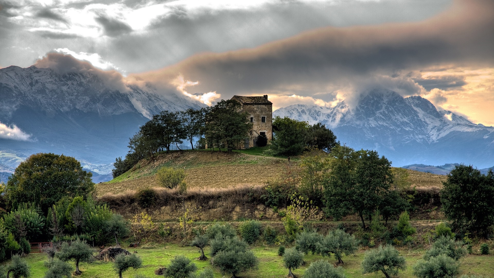 Old building on a hill with mountains in the background HD Wallpaper