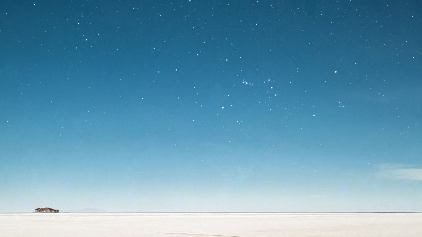 A lone building on a salt flat under a starry sky HD Wallpaper