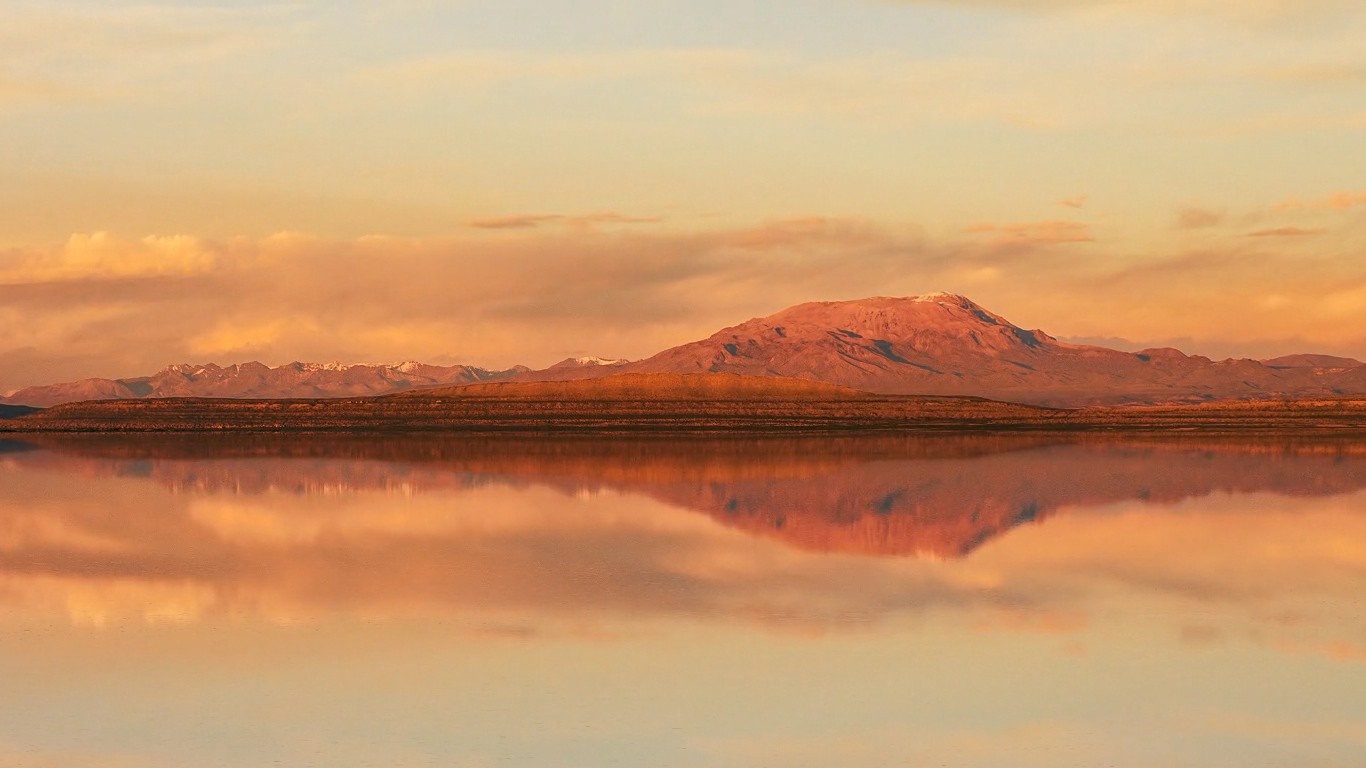 Mountain reflection at sunset over a calm body of water HD Wallpaper