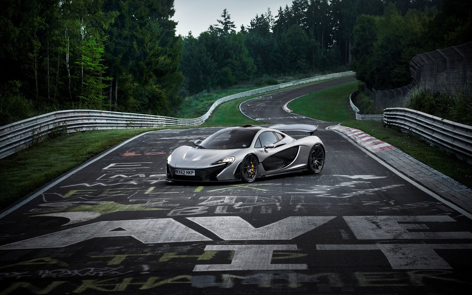 Silver McLaren P1 supercar on a race track HD Wallpaper