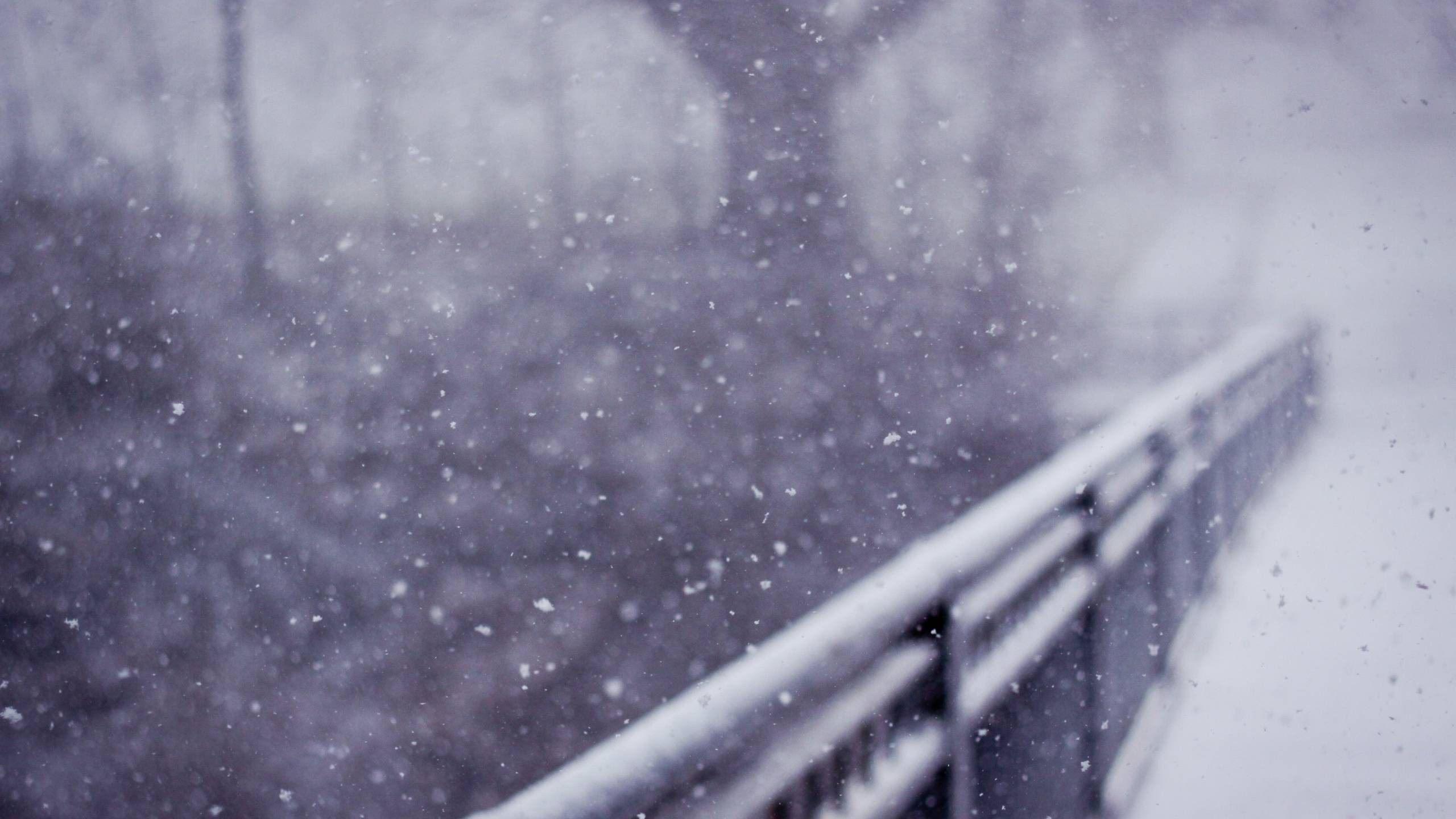 Snow falling on a railing during winter HD Wallpaper