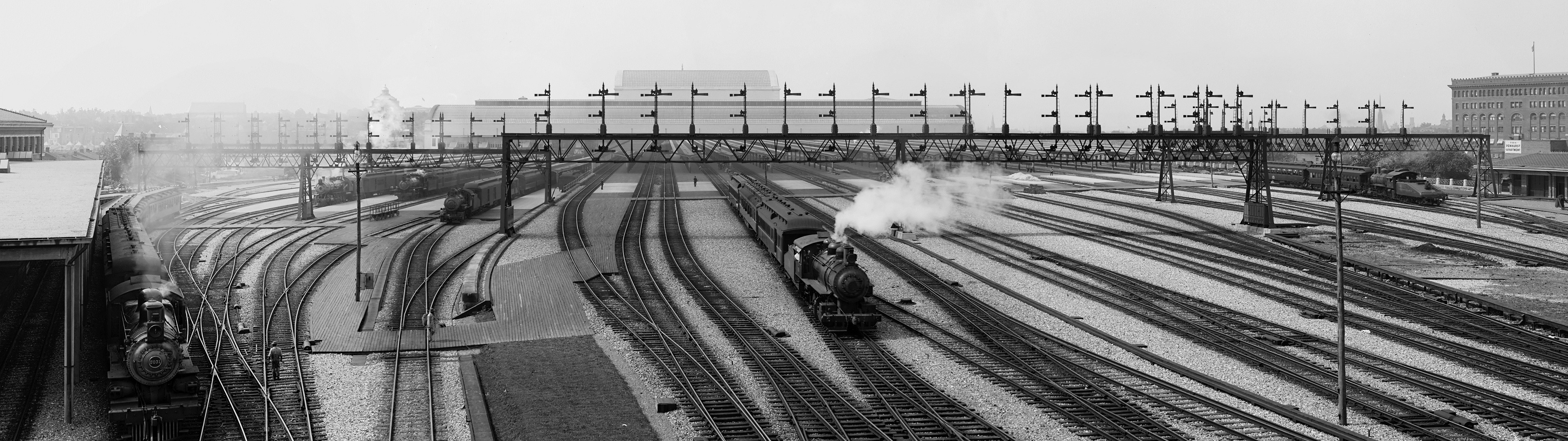 Steam locomotives in a busy rail yard with multiple tracks HD Wallpaper