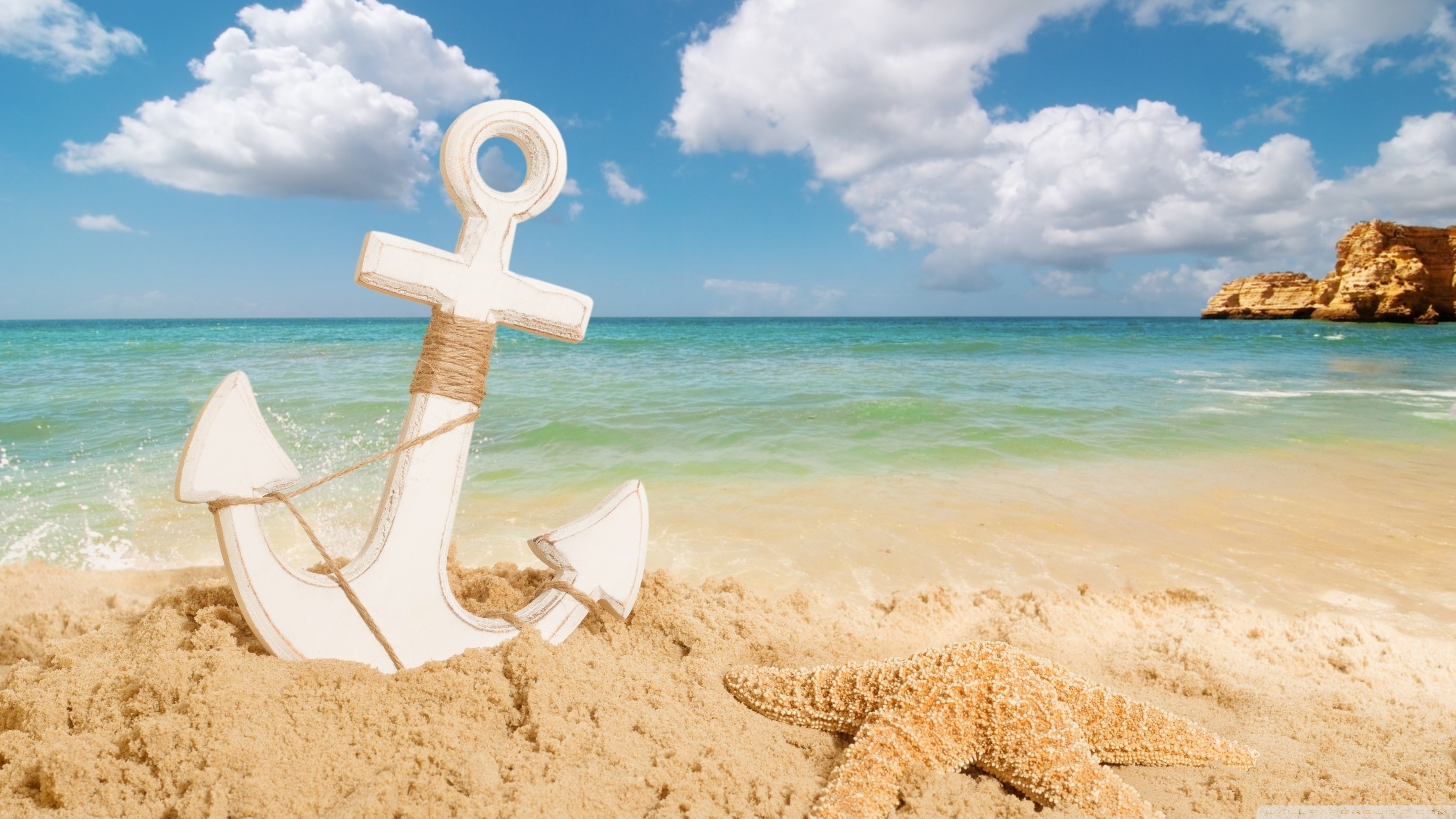 Anchor and starfish on a sandy beach with ocean waves HD Wallpaper