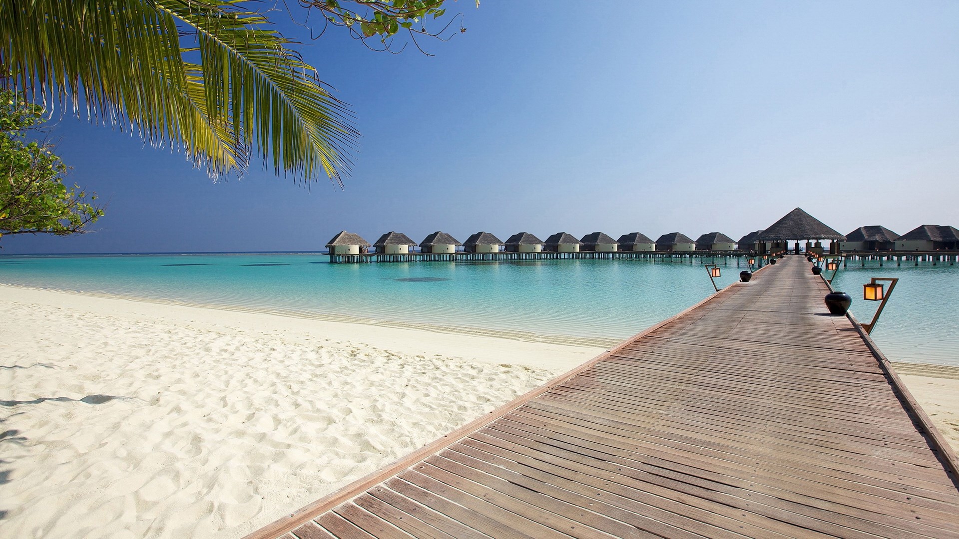Wooden pier leading to overwater bungalows in the Maldives HD Wallpaper