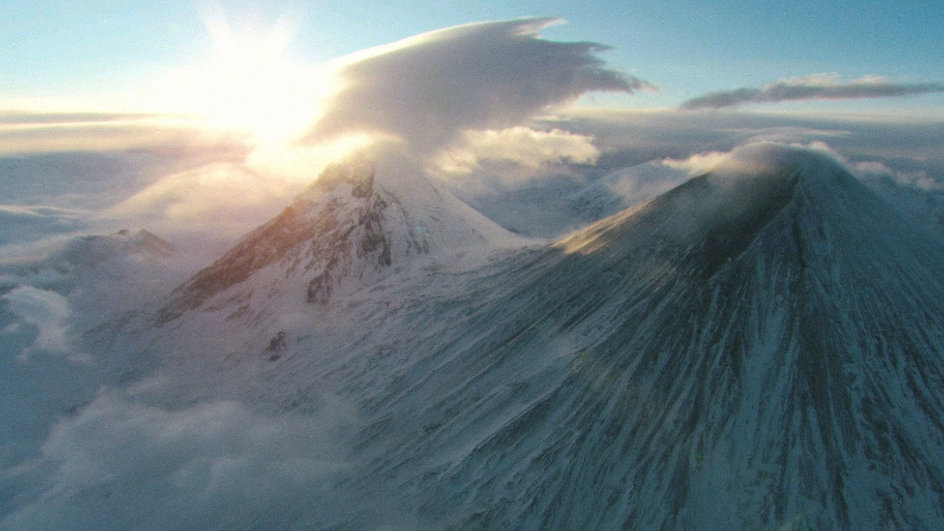 Snow-covered volcanoes under a sunrise with clouds HD Wallpaper