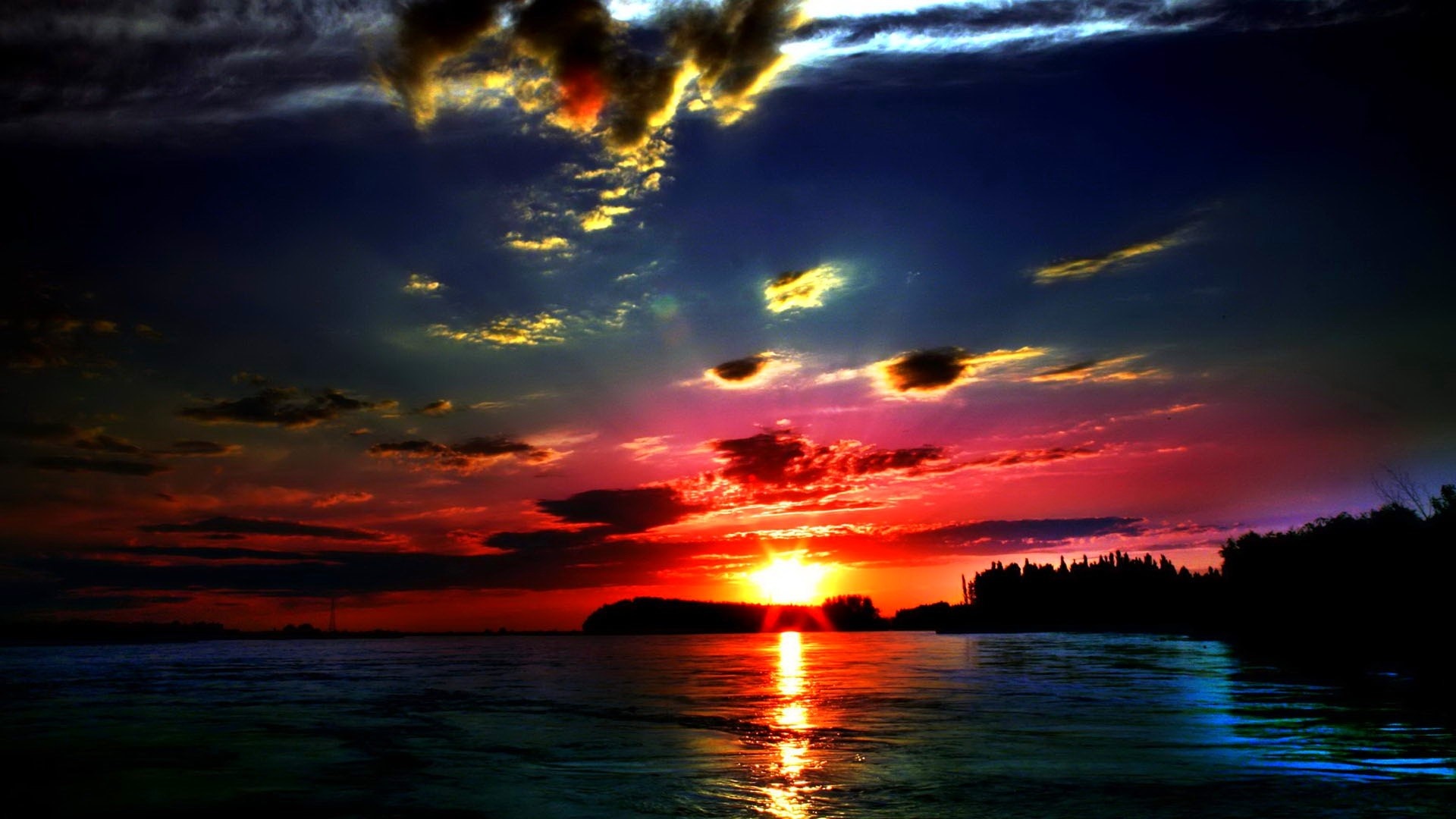 Vibrant sunset over the sea with colorful clouds and reflections HD Wallpaper