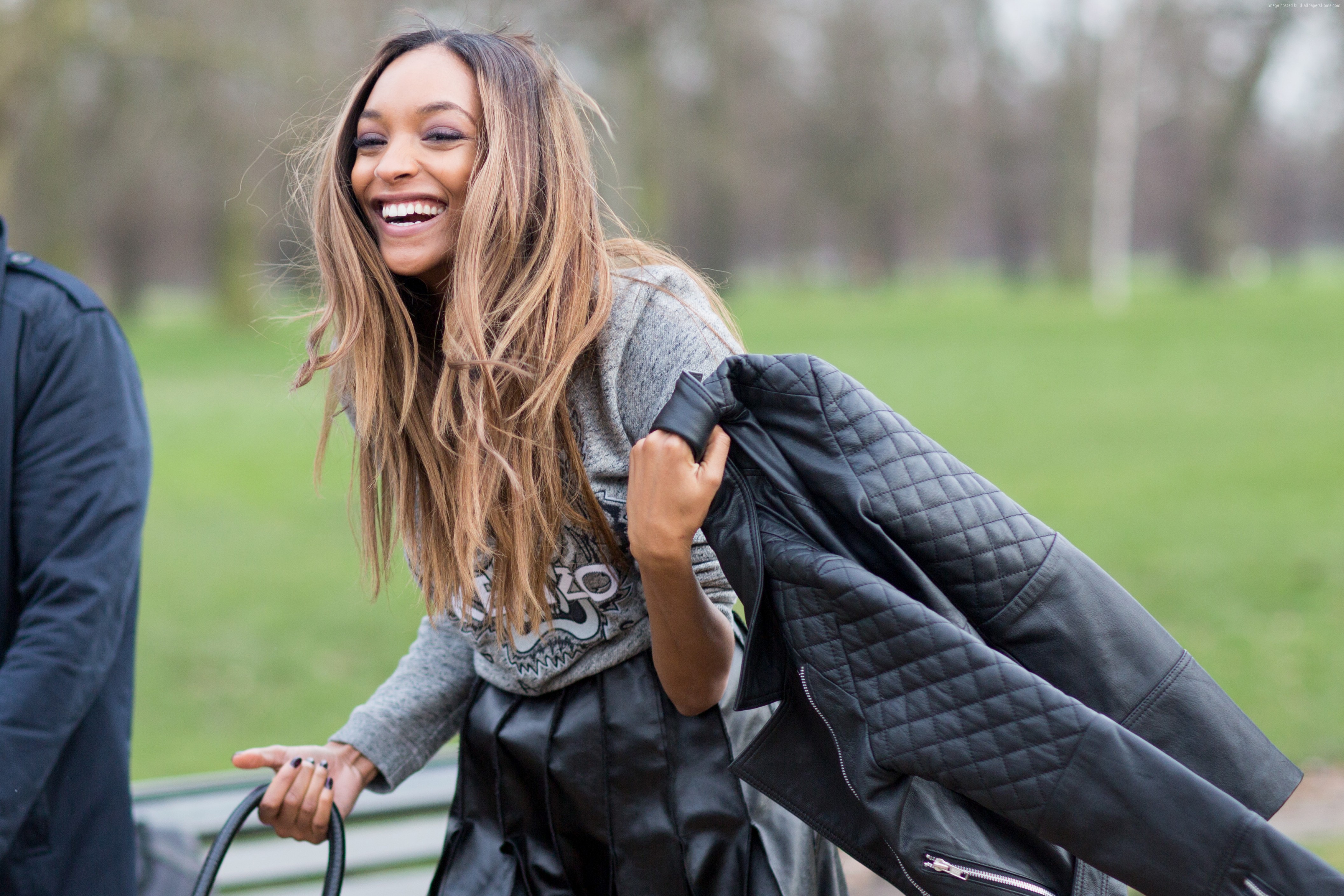 Jourdan Dunn laughing outdoors holding a leather jacket HD Wallpaper